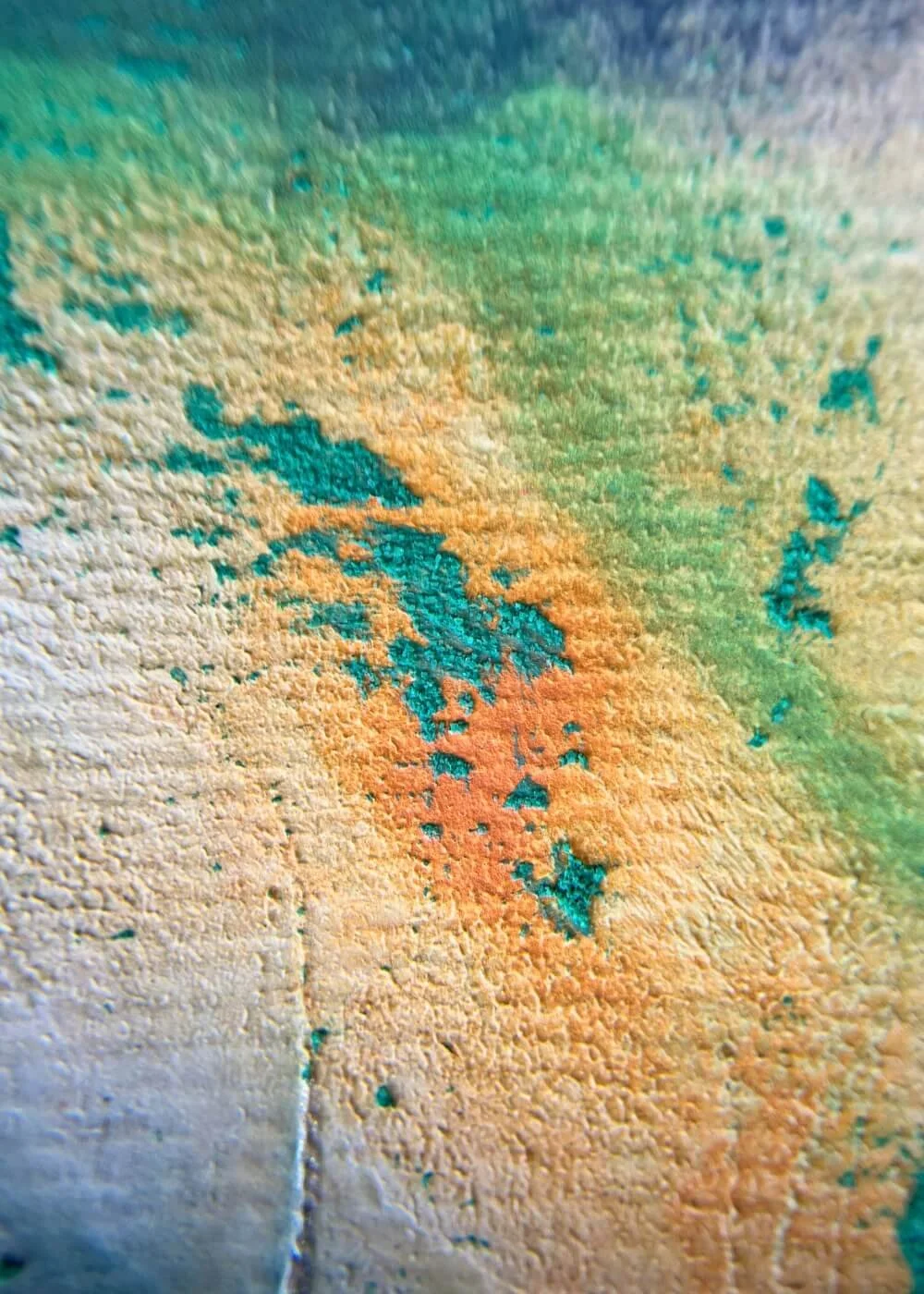 Macro detail of orange and green textured pigments in ‘Between Lifting and Letting Go’, highlighting tactile depth and the energy of release and transformation.