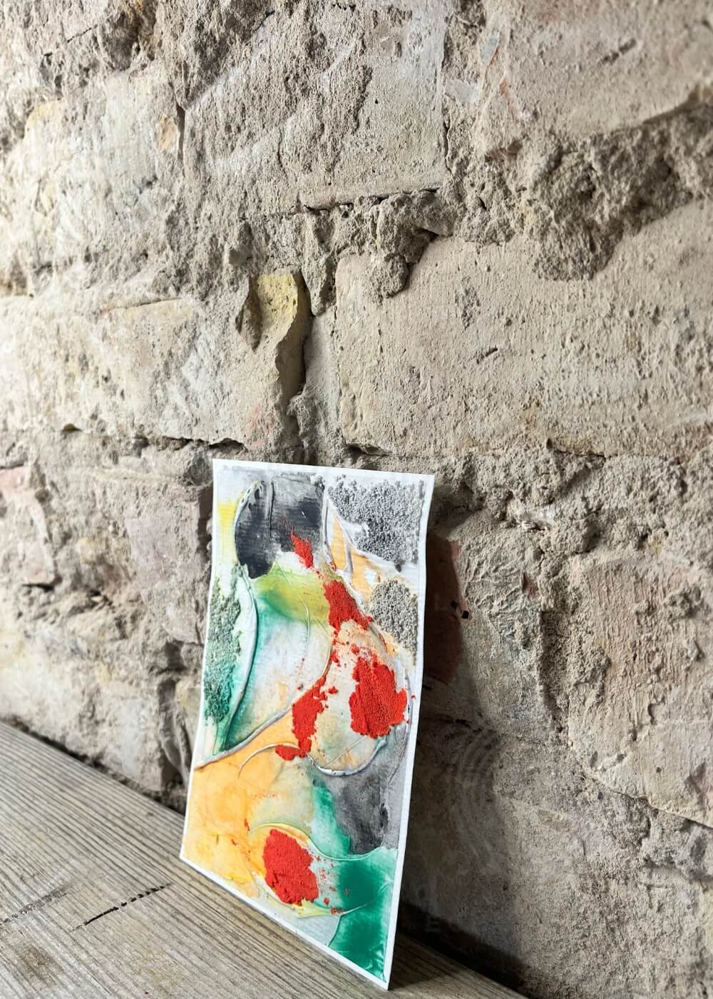 Side perspective of the painting Risen through fire, showing dimensional textures and bold color contrasts of red, black, and green.