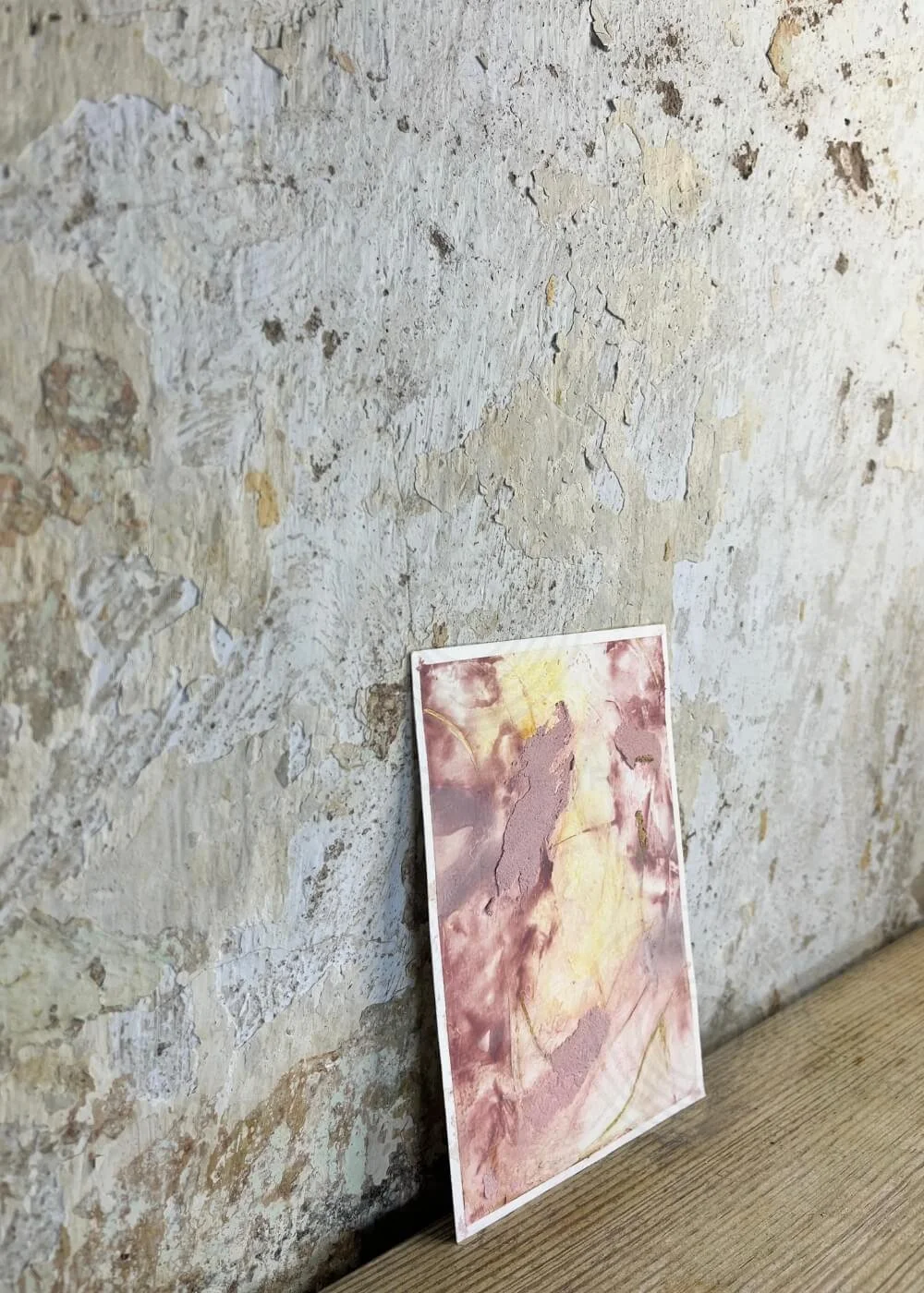 Side view of “Held by Myself No. 1” – tactile healing artwork with soft rose and golden textures leaning gently against a rustic wall.