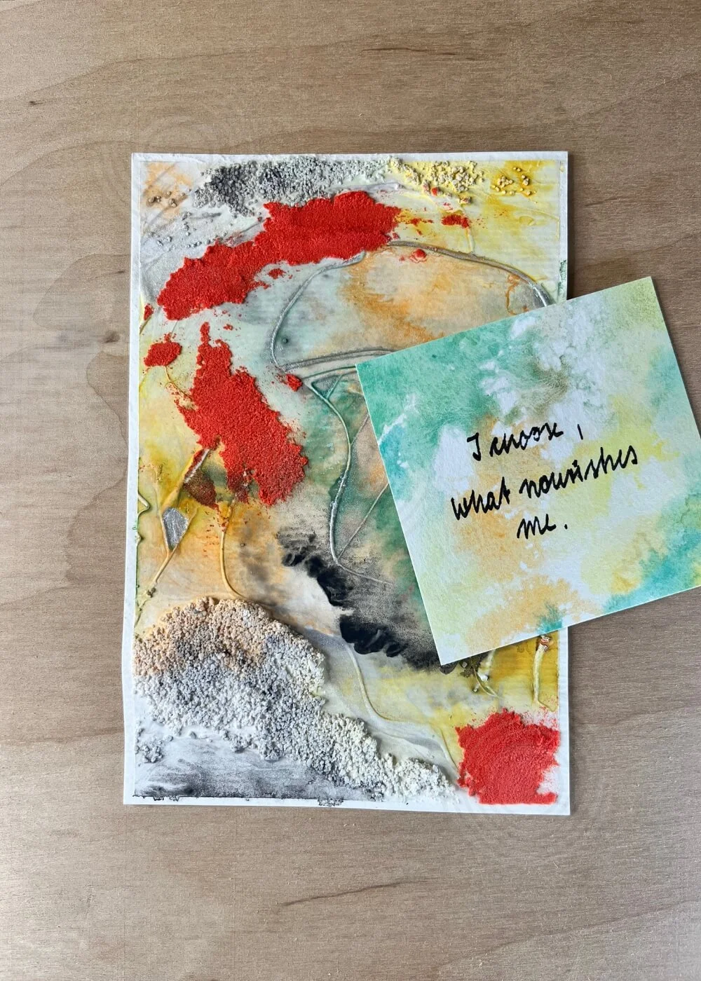 Close-up of artwork with affirmation card – I know what nourishes me – highlighting vibrant red and green tones with tactile texture.