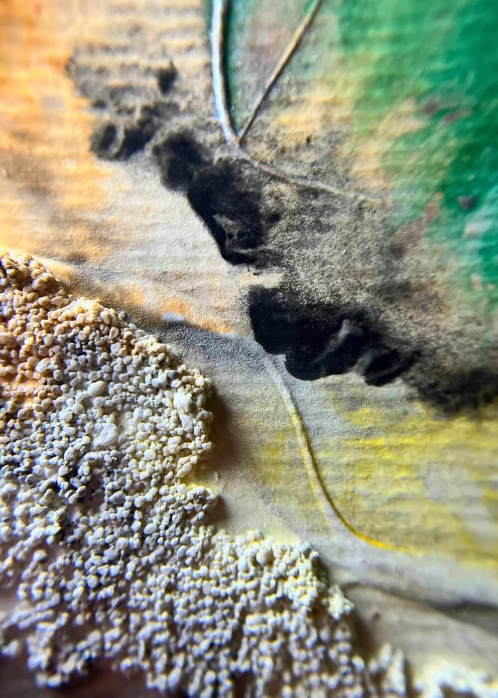 Macro shot of textured artwork with black and white contrast, rough granules, and green-yellow gradients symbolizing grounding and inner spark.