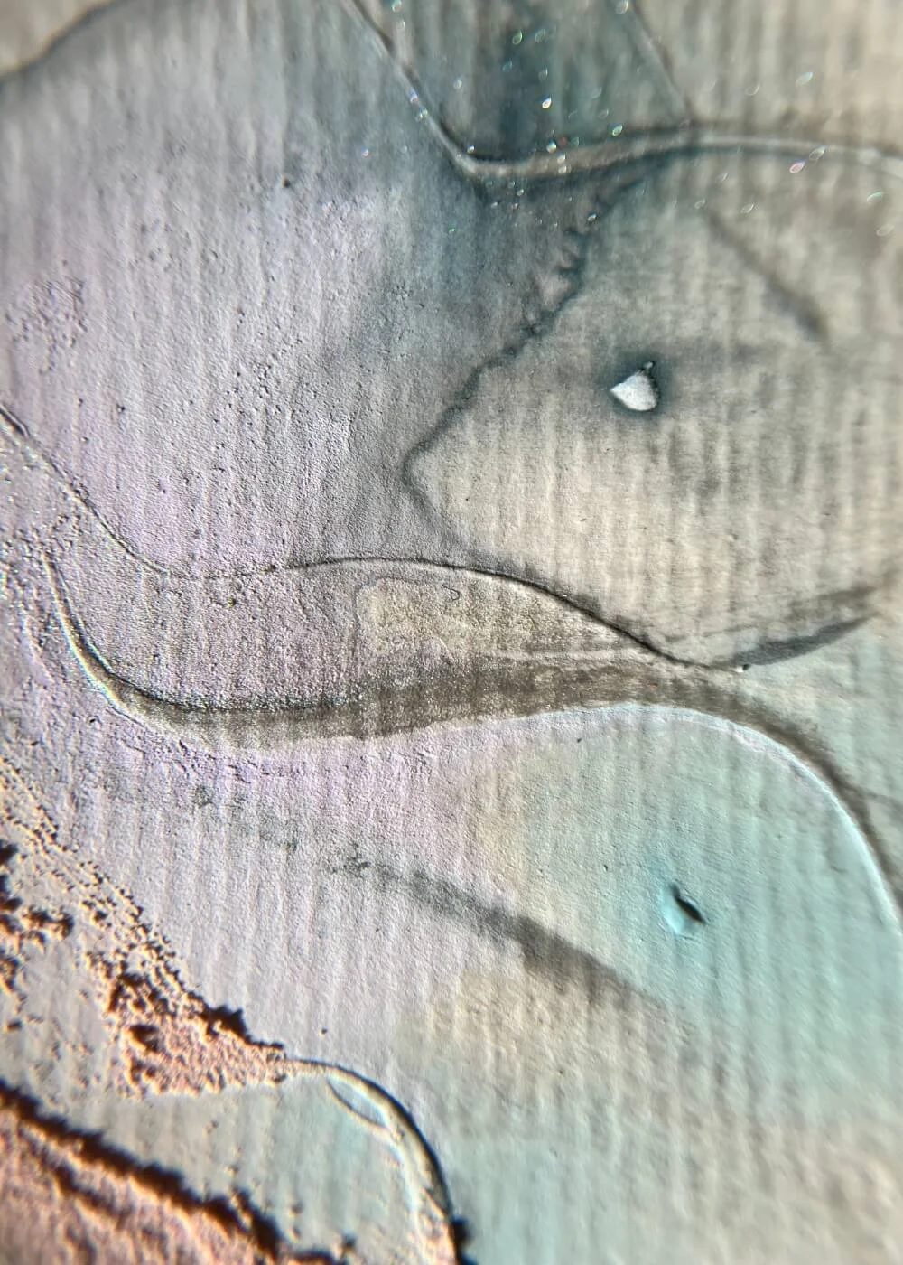 Detailed close-up of pale lavender and teal pigments blending across textured plaster, emphasizing fluid depth and emotional continuity.