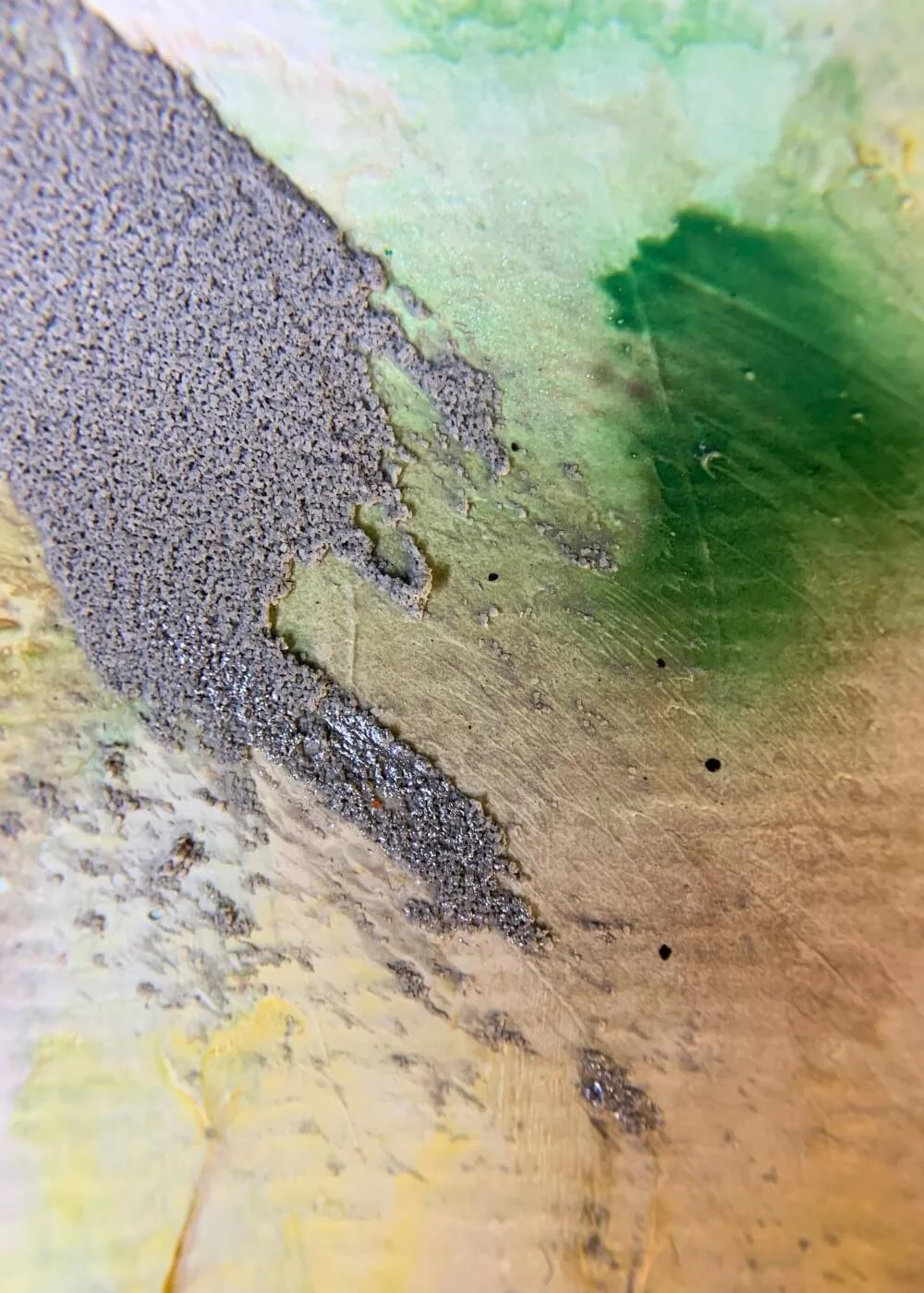 Macro close-up of textured mixed-media surface from Between the Seconds – No. 3, featuring rough grey pigment against soft green.
