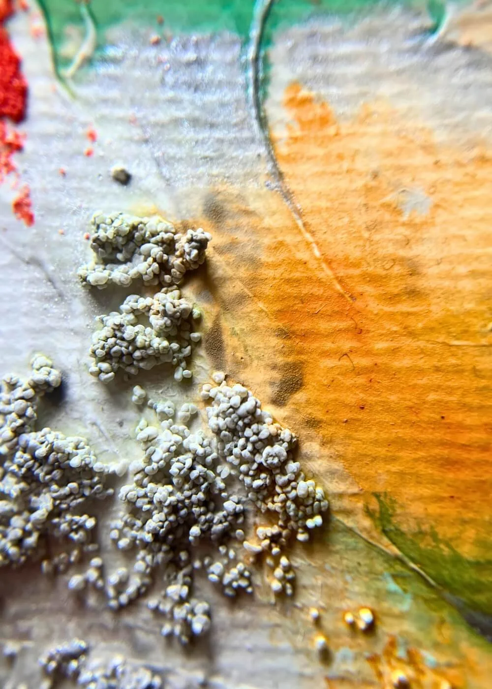 Texture close-up of "The light I let in" painting – granular white structures over orange and yellow tones, highlighting the tactile mixed media surface.