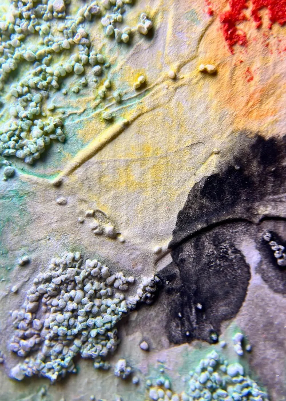 Detailed macro of layered textures in “The boundary that loves,” showing soft grains and black pigments evoking grounded resilience.