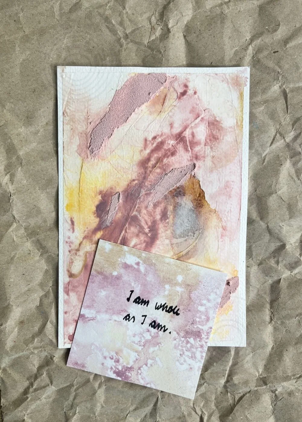 Postcard-sized mindfulness artwork “Held by Myself No. 4,” resting on kraft paper beside an affirmation card affirming self-love and presence.