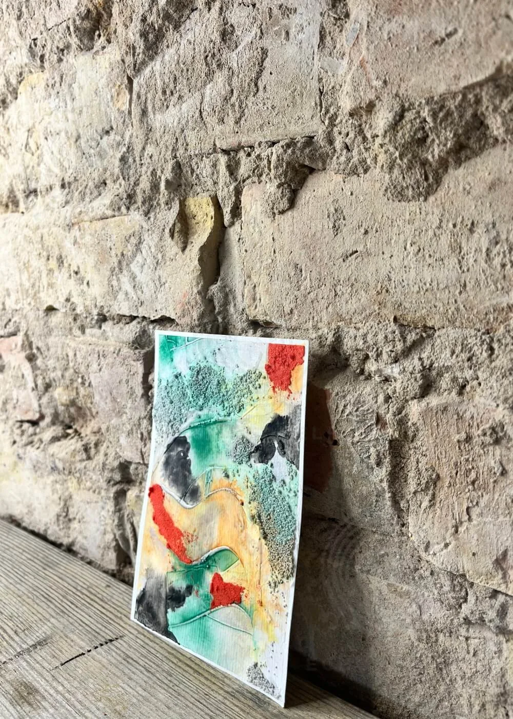 Multisensory painting “The boundary that loves” leaning against a rustic wall, blending textures of strength and tenderness.