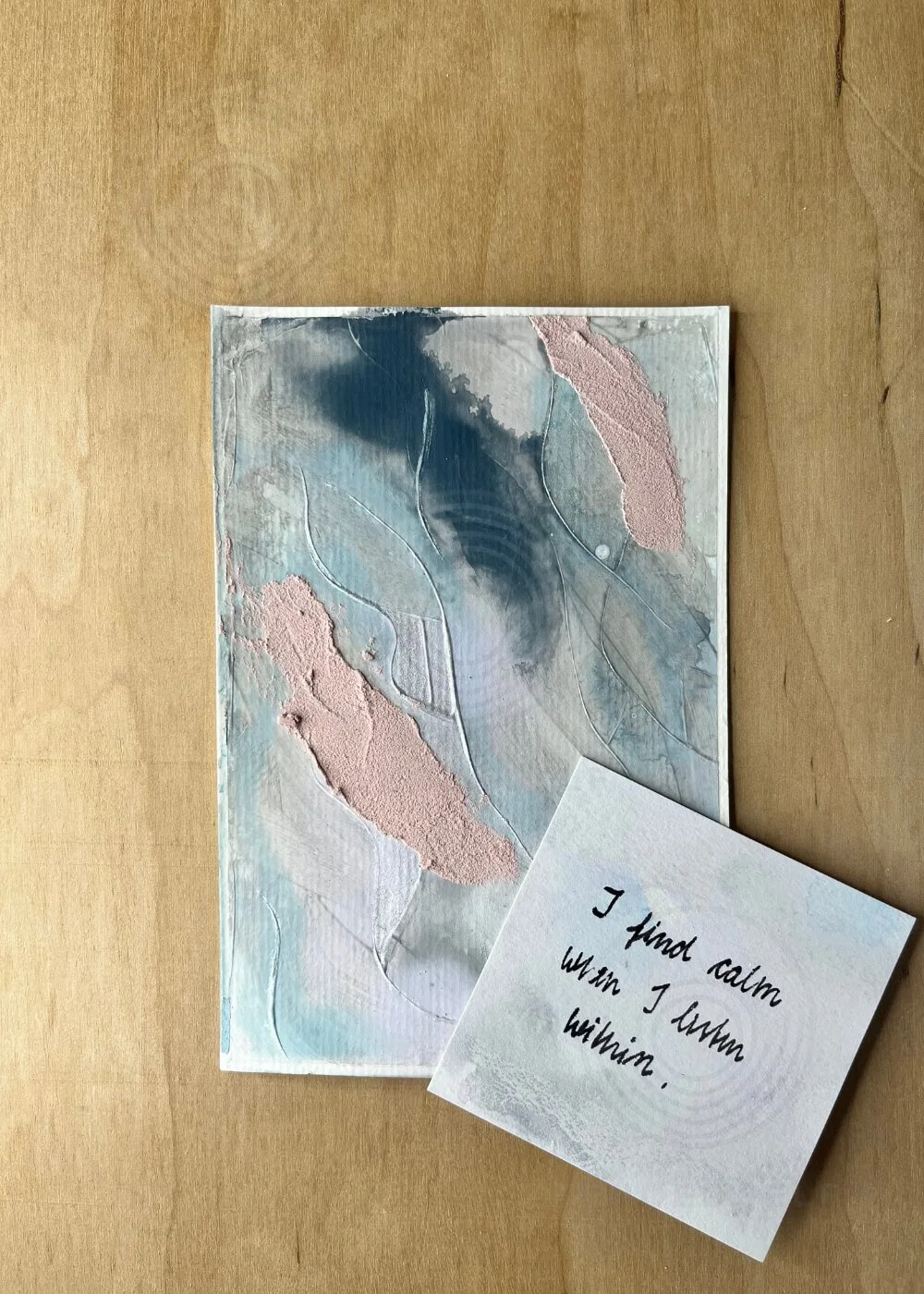 The artwork In the Space Between Thoughts accompanied by a handwritten affirmation reading ‘I find calm when I listen within,’ expressing the contemplative essence of the piece.