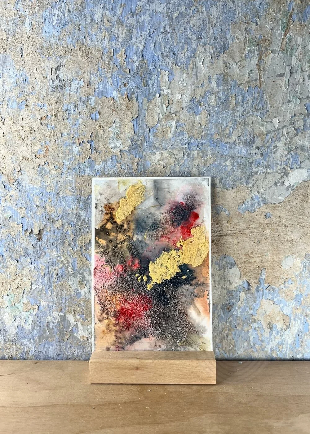 Abstract mixed-media artwork in warm, golden and ember-red hues — symbolising self-acceptance and rebirth after the fire.