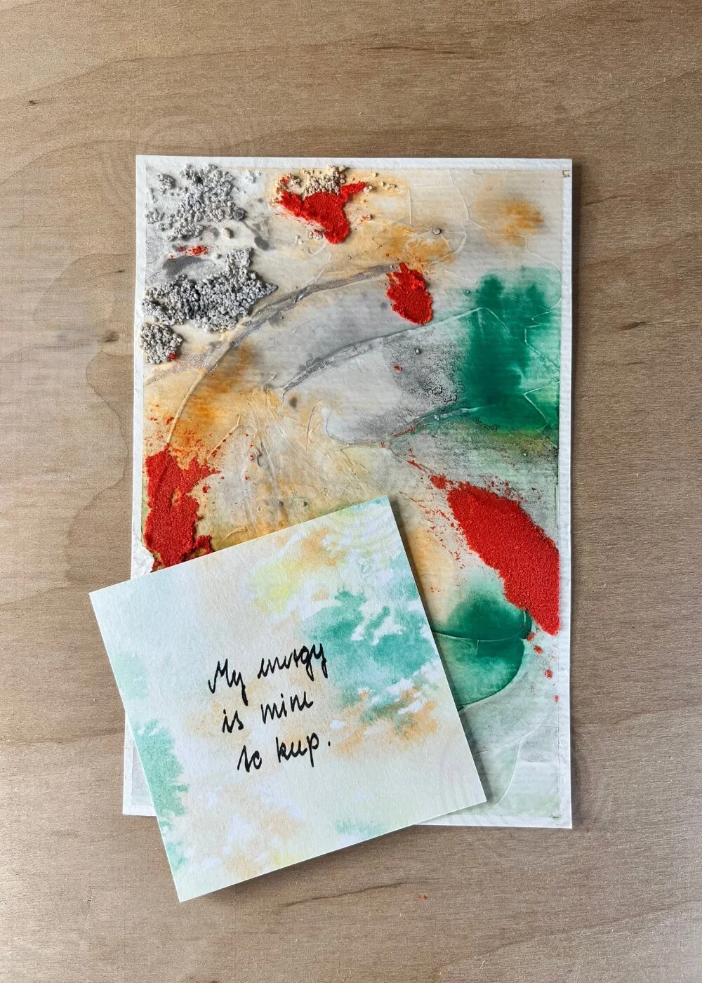 Abstract artwork with an accompanying affirmation card reading “My energy is mine to keep” on a light wooden surface.