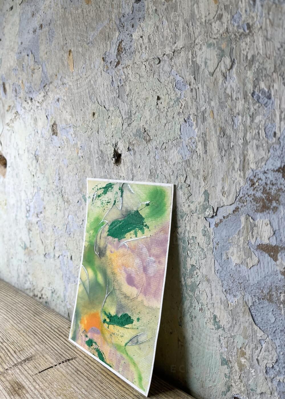 Side perspective of ‘Between the colors’, textured mixed media painting with bold green accents, soft violet tones, and warm orange highlights representing transformation and balance.