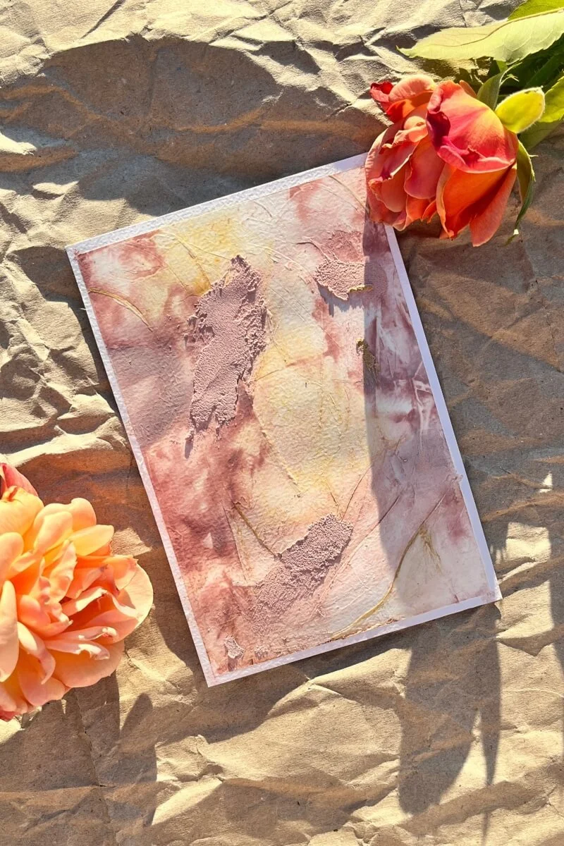 “Abstract textured artwork from the ‘Held by Myself’ series, bathed in warm sunlight and framed by orange roses — a visual metaphor for gentle healing and inner growth.