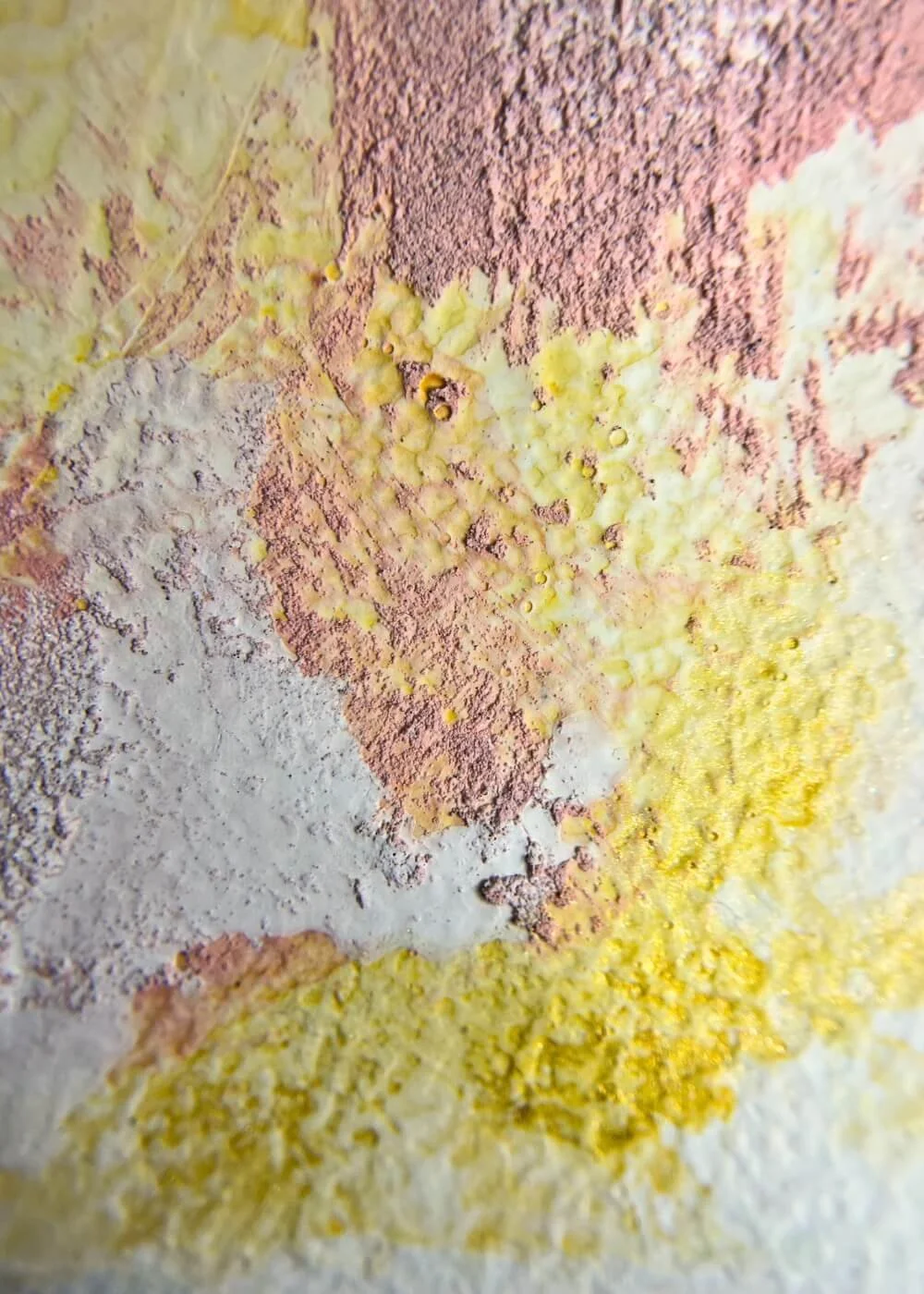Close-up of textured mixed media artwork "Held by myself No. 9" showing rough surface details in golden yellow and soft pink pigments.