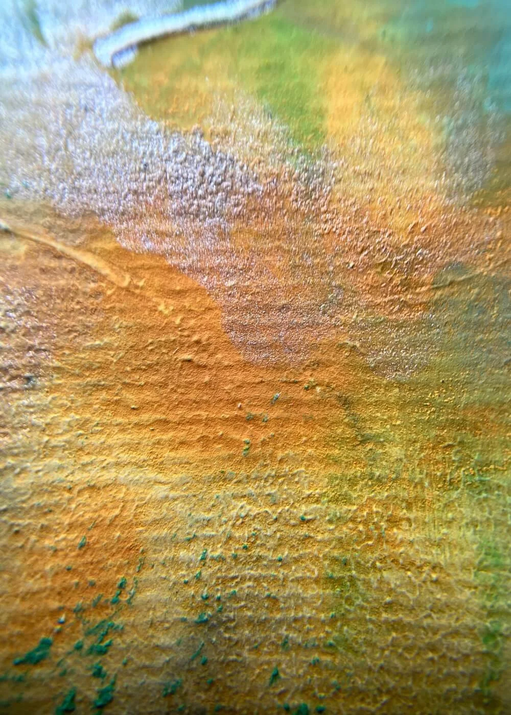 Macro detail of textured orange and gold surface from The beginning glows within me, showing layered paint and organic flow.