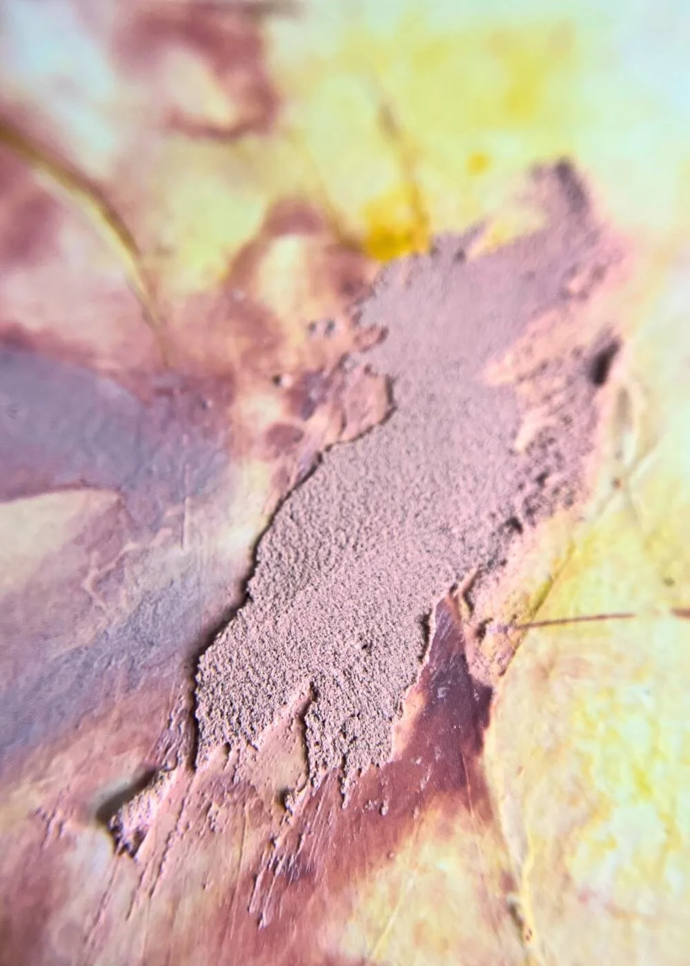 Macro detail of abstract mindfulness art, highlighting raised pink texture against a warm blend of yellow and rose hues.
