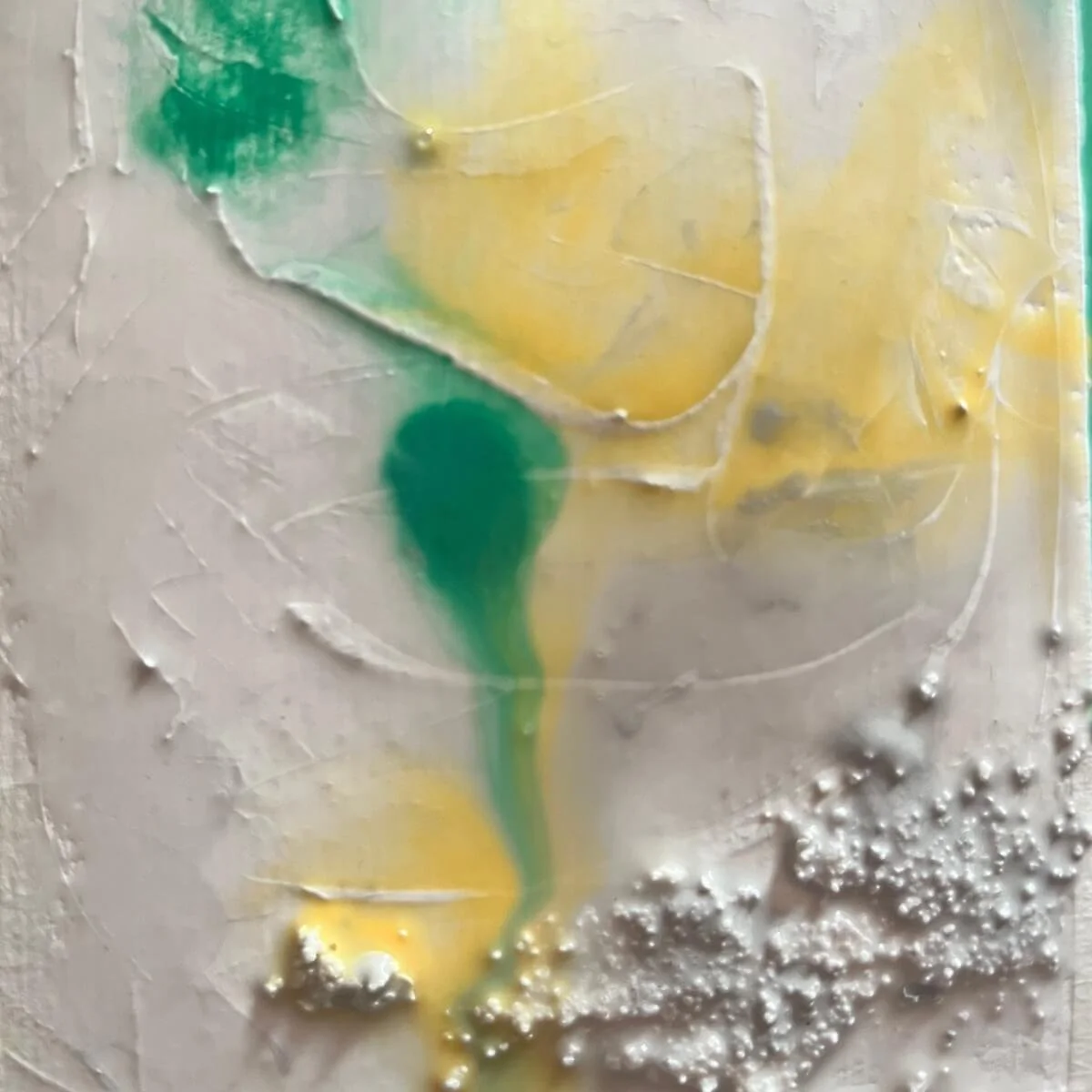 Close-up of a work in progress from the Built Of Light series. Vivid yellow and green pigments flow softly into each other, forming organic transitions. Fine grains of sand add tactile texture and depth to the wet surface.