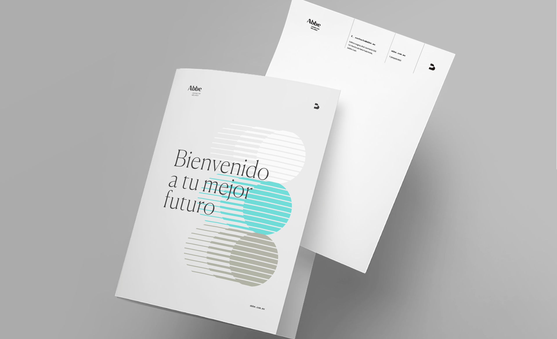 Folletos blancos sobre una mesa gris, uno con texto 'Bienvenido a tu mejor futuro' y el otro con información de contacto