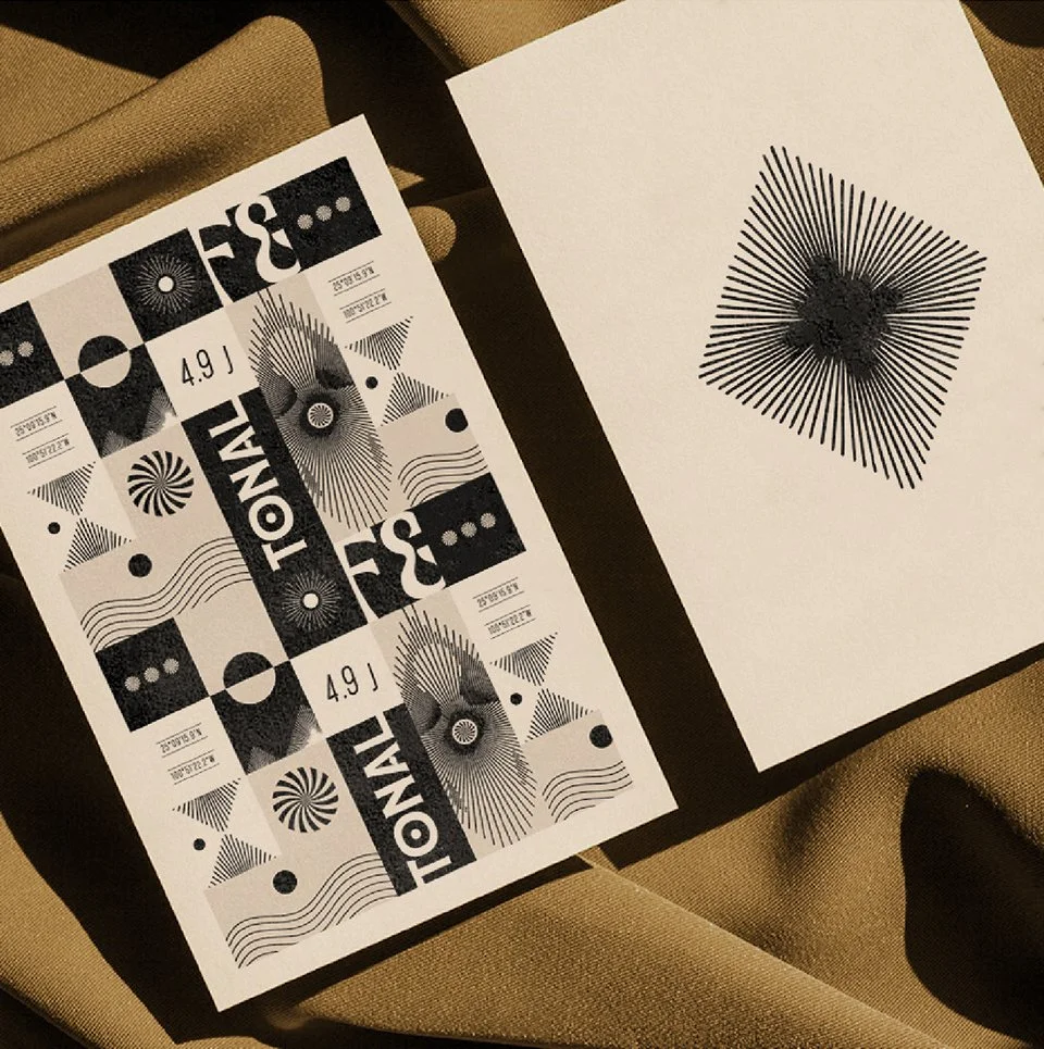 Dos boletos de lotería negros y blancos con diseños geométricos, uno de ellos tiene la palabra "TOMA" y otro número 4.9 J y una hoja en blanco con un dibujo en línea negra parecido a un patrón de líneas radiantes.