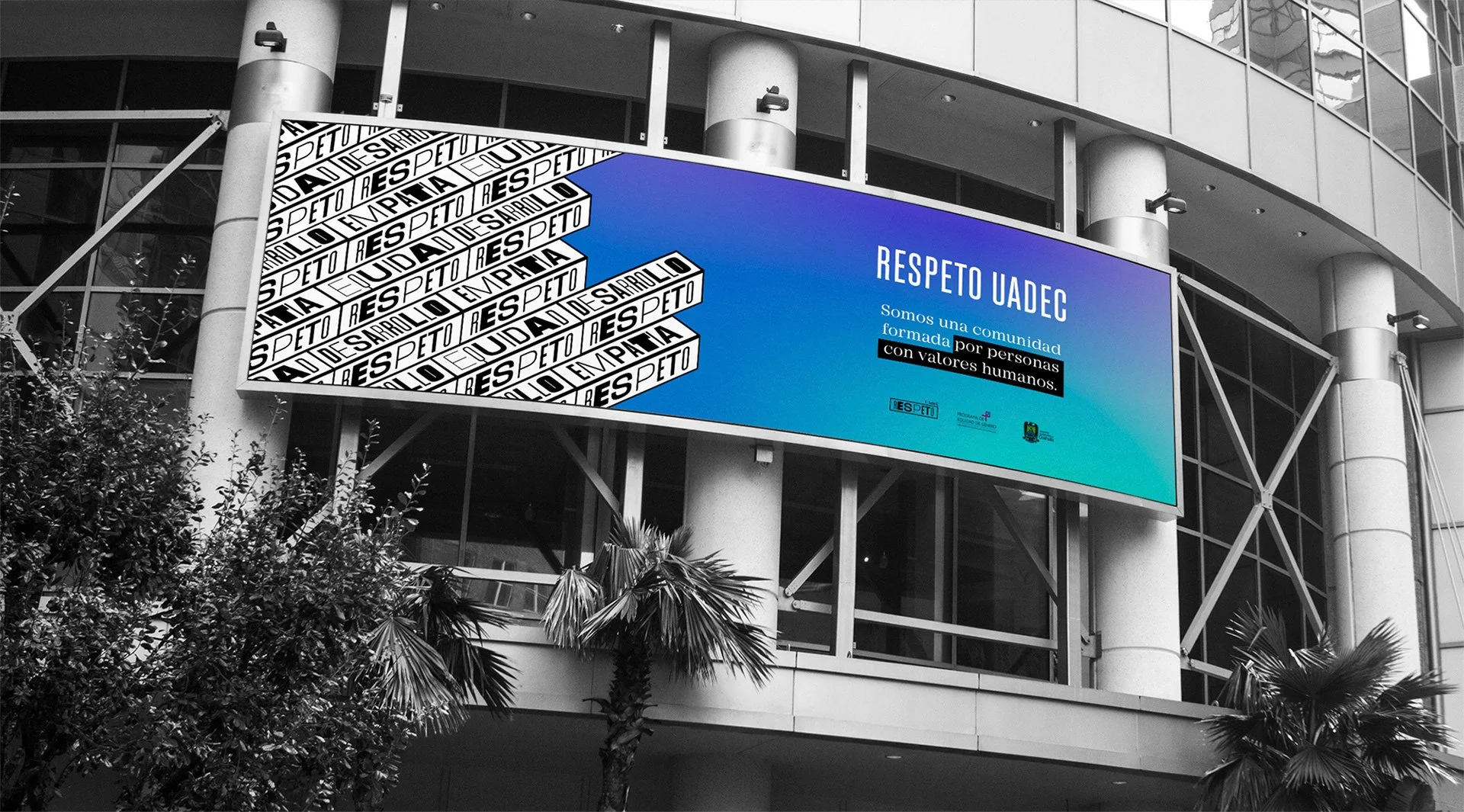Cartel digital en un edificio moderno con mensajes sobre respeto y comunidad, incluidas frases en español, en un fondo azul y diseño en blanco y negro.