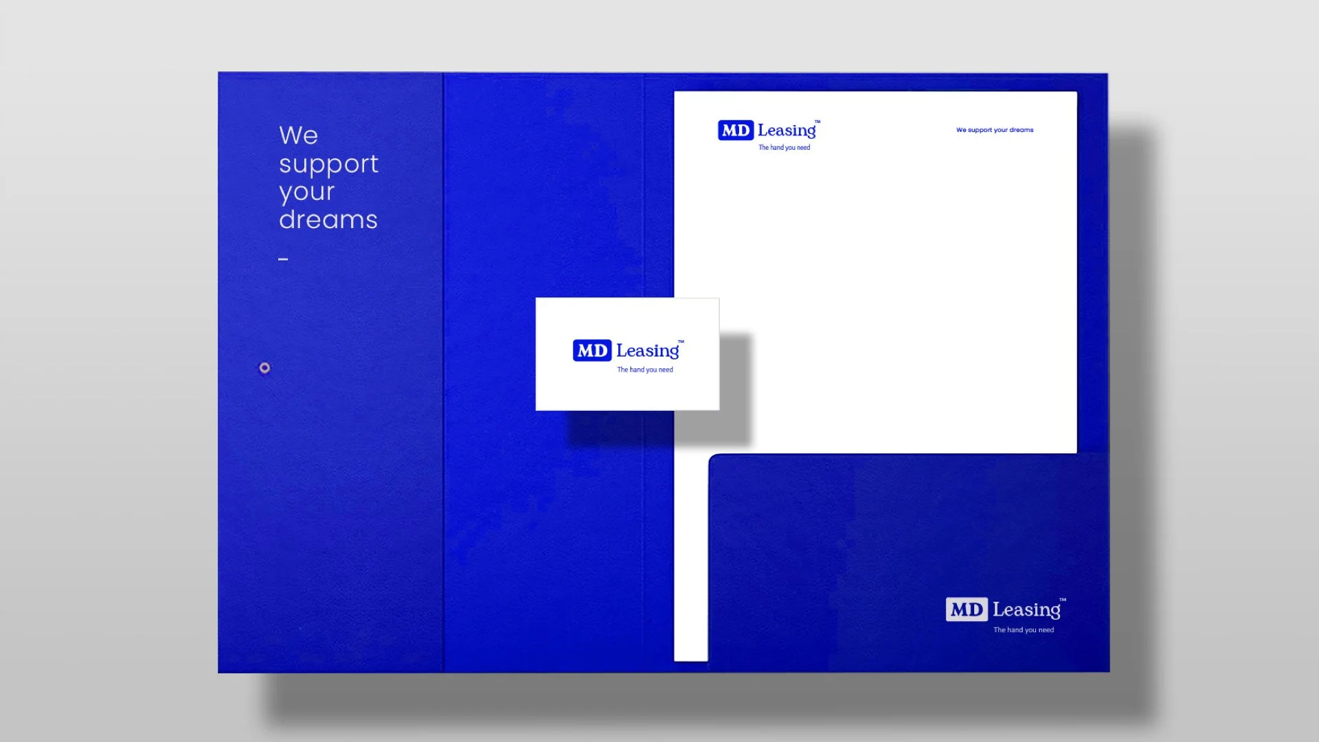 Set de papelería azul con logotipo de MD Leasing, con la frase "We support your dreams" y una caja para documentos.