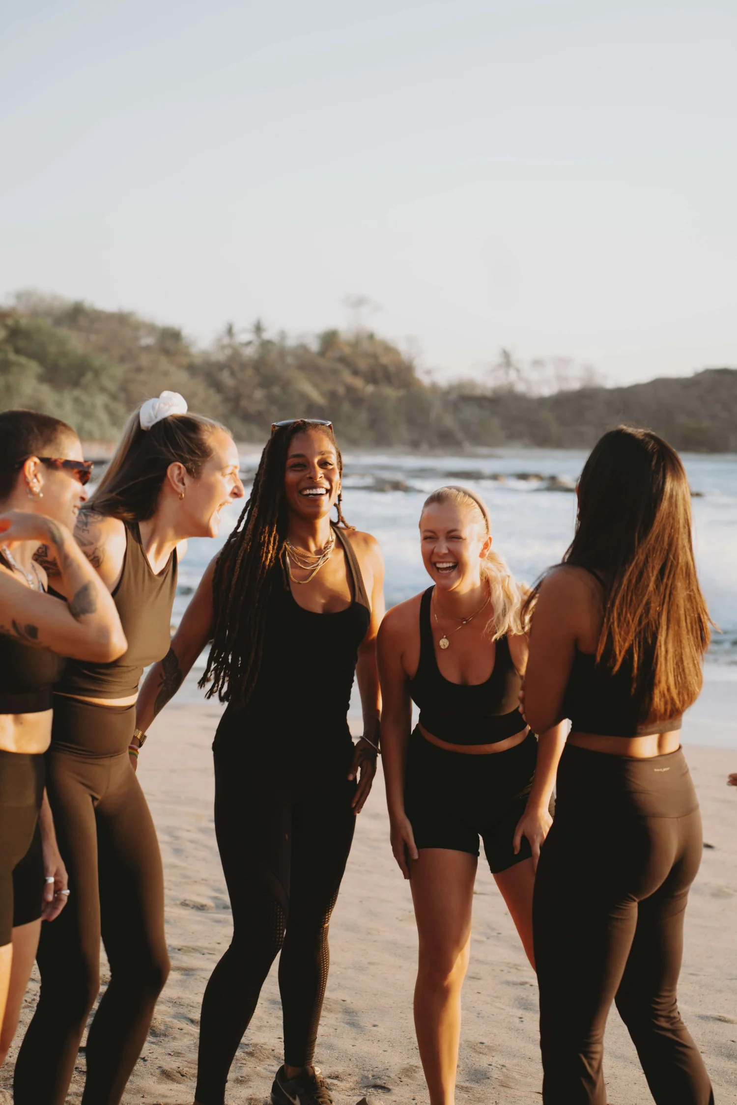 Group of women laughing on the beach at sunset in Nosara
