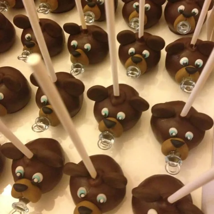 Chocolate cake pops decorated as teddy bears with pacifiers and sticks