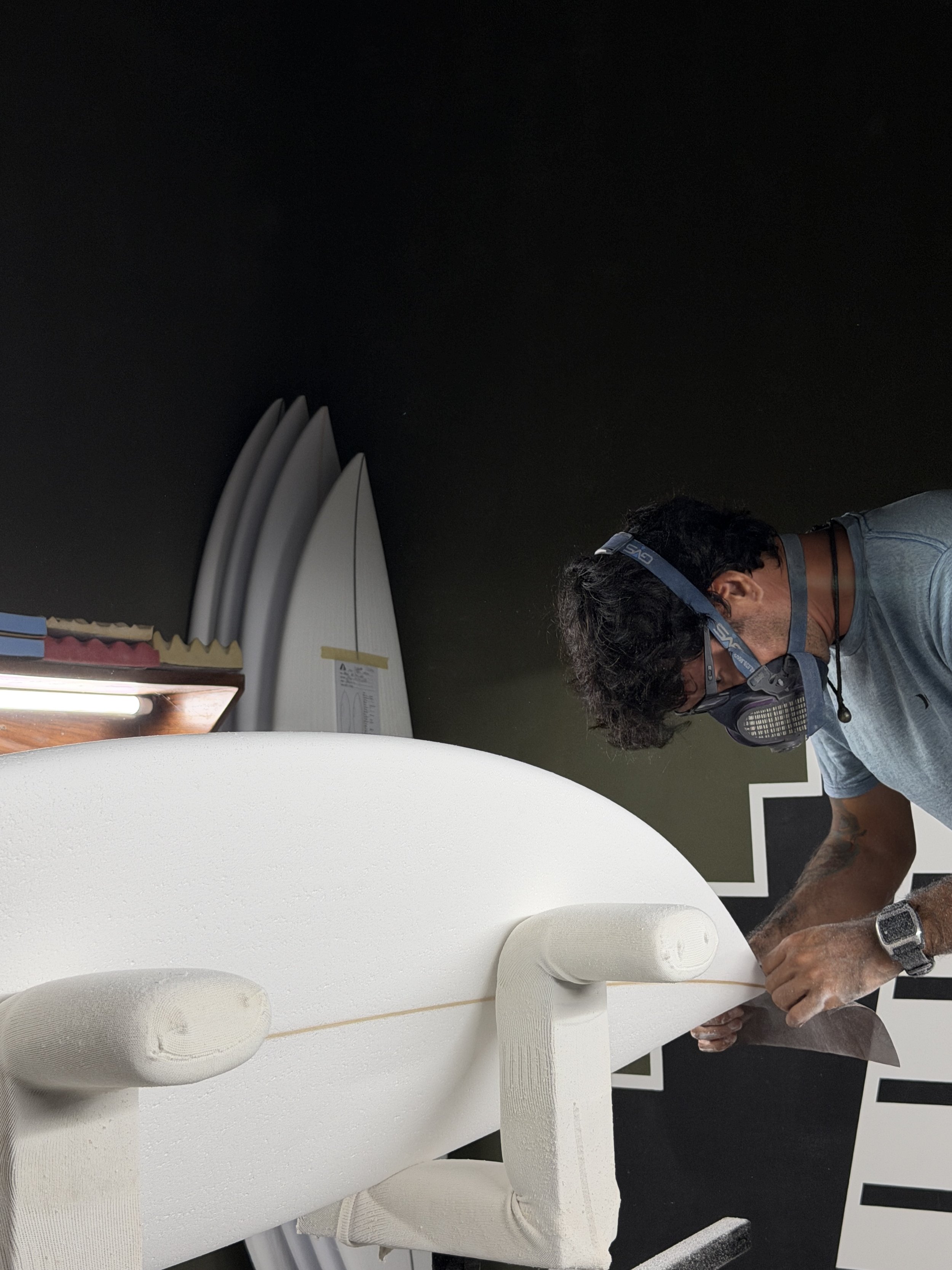 Un experto modelador de tablas de surf está perfeccionando el núcleo de espuma para una tabla personalizada hecha en México.