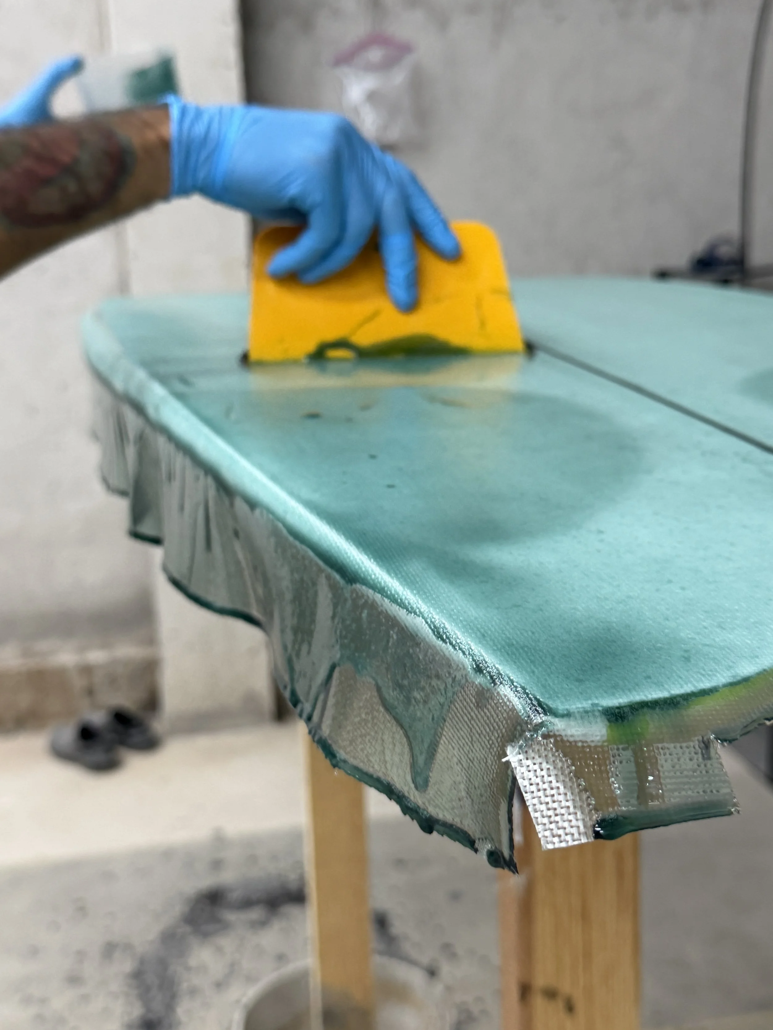 Fabricación de una tabla de surf con resina de alta calidad y tela de fibra de vidrio.