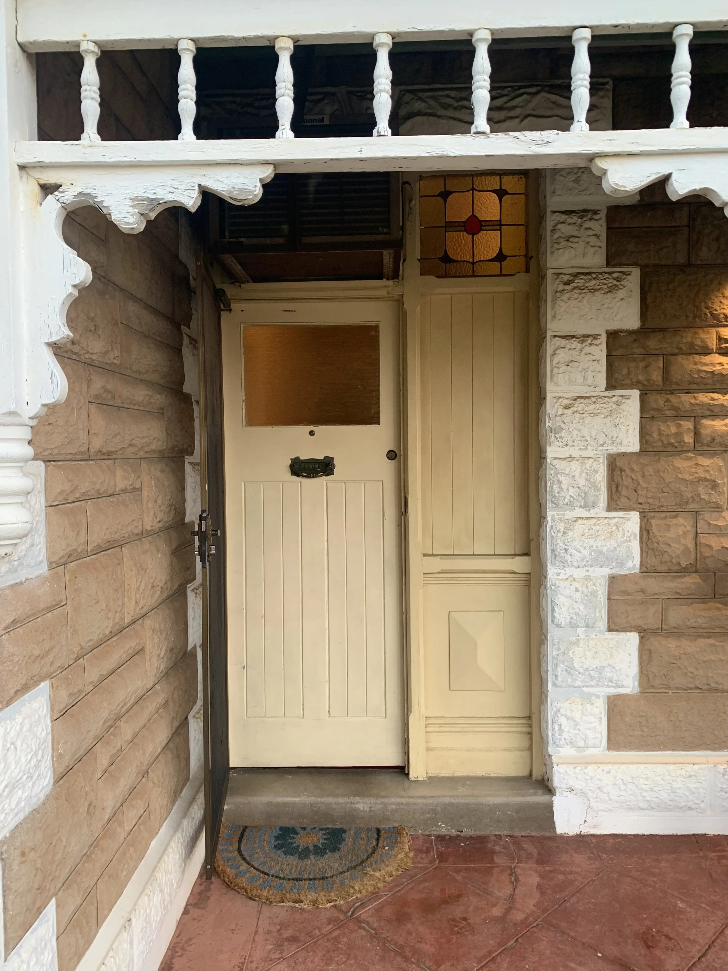 Removal of the existing door and frame to install a custom-built Victorian-style door frame, complete with sidelights and embellished moulding.