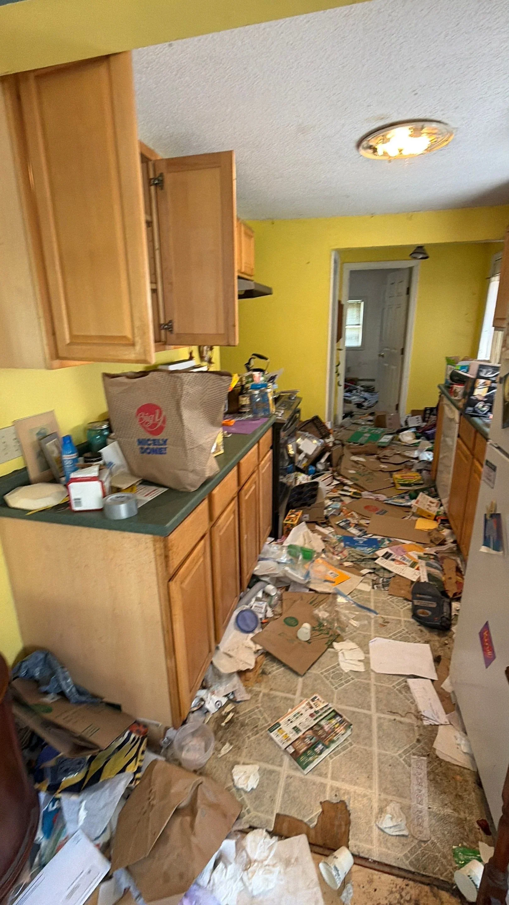 Eviction cleanout in progress: kitchen interior of a rental property with debris left by previous tenants.