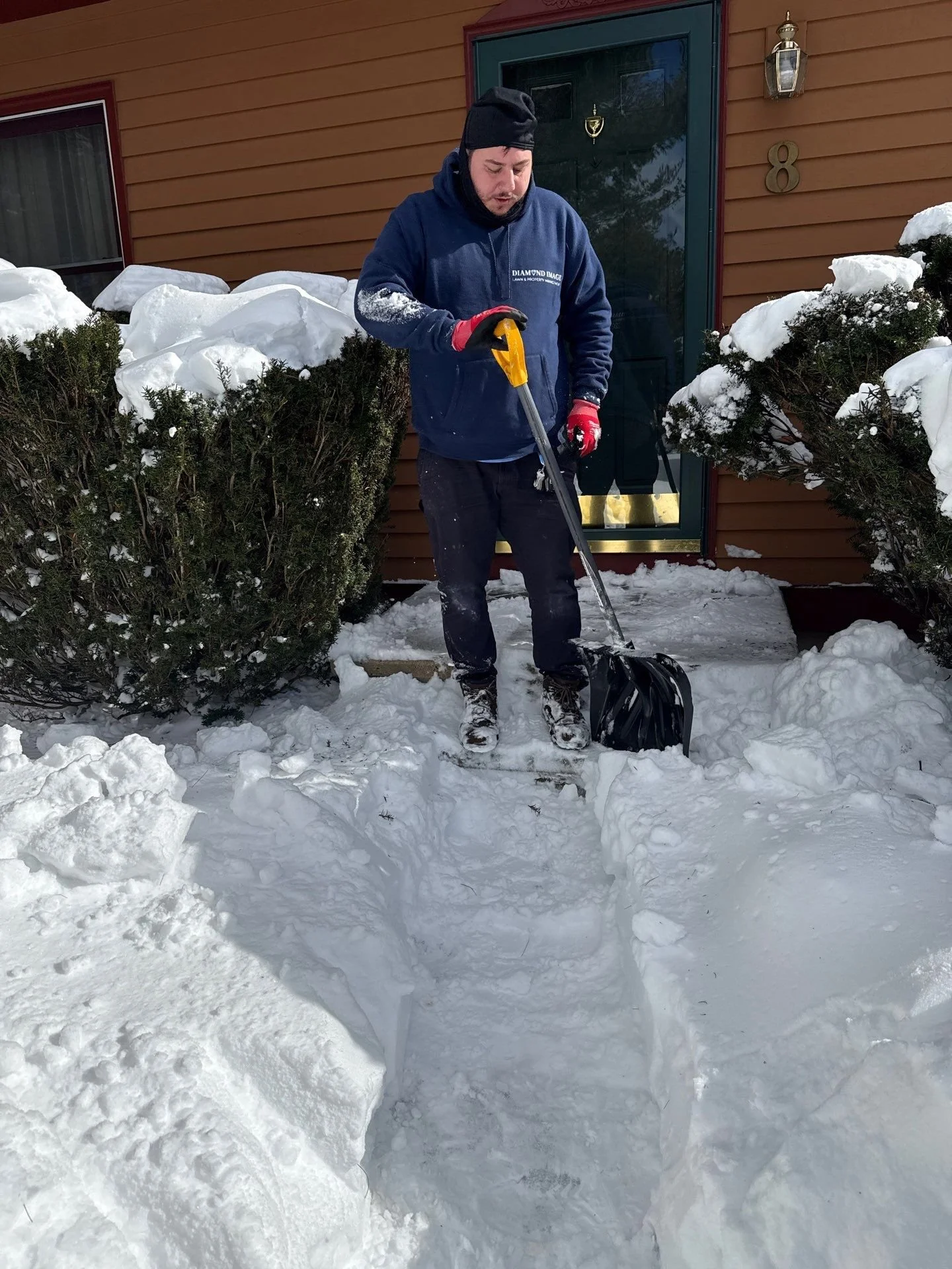 Diamond Image crew member shoveling snow from a residential driveway in New Haven, CT