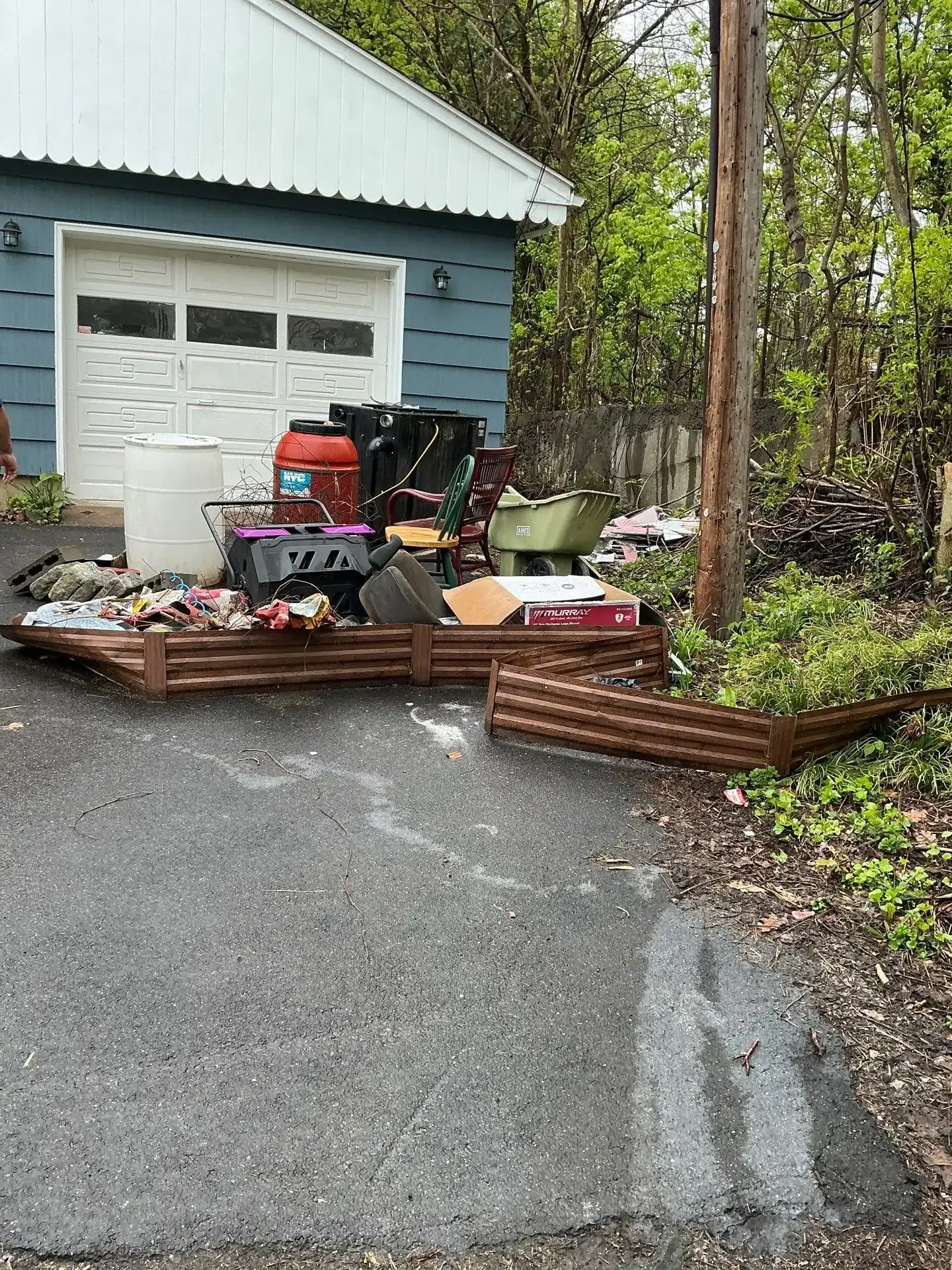 Driveway staging during a residential property cleanout, with items pulled from the home awaiting haul-away.