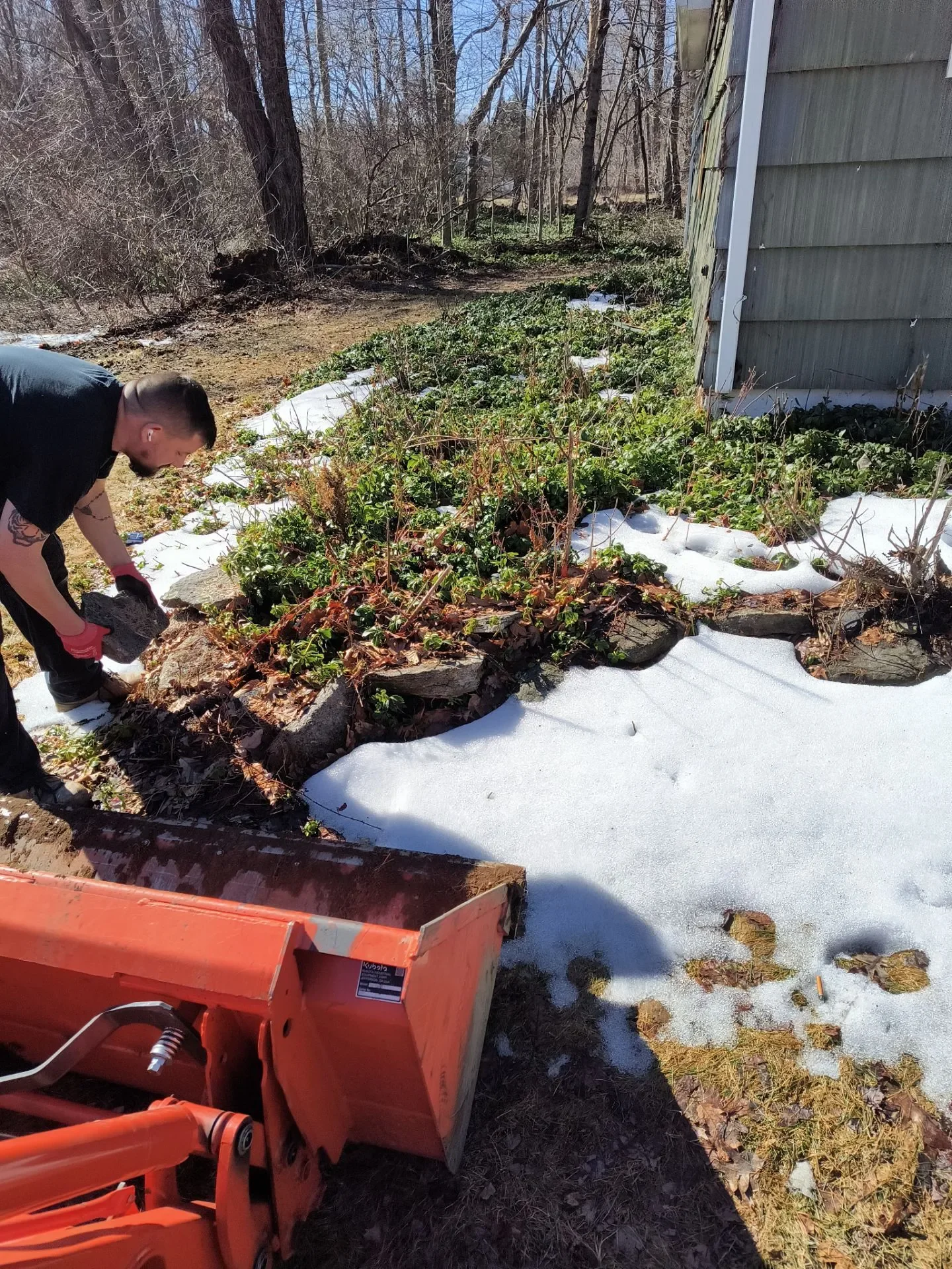 Spring yard cleanup around garden beds at a home in New Haven County, CT
