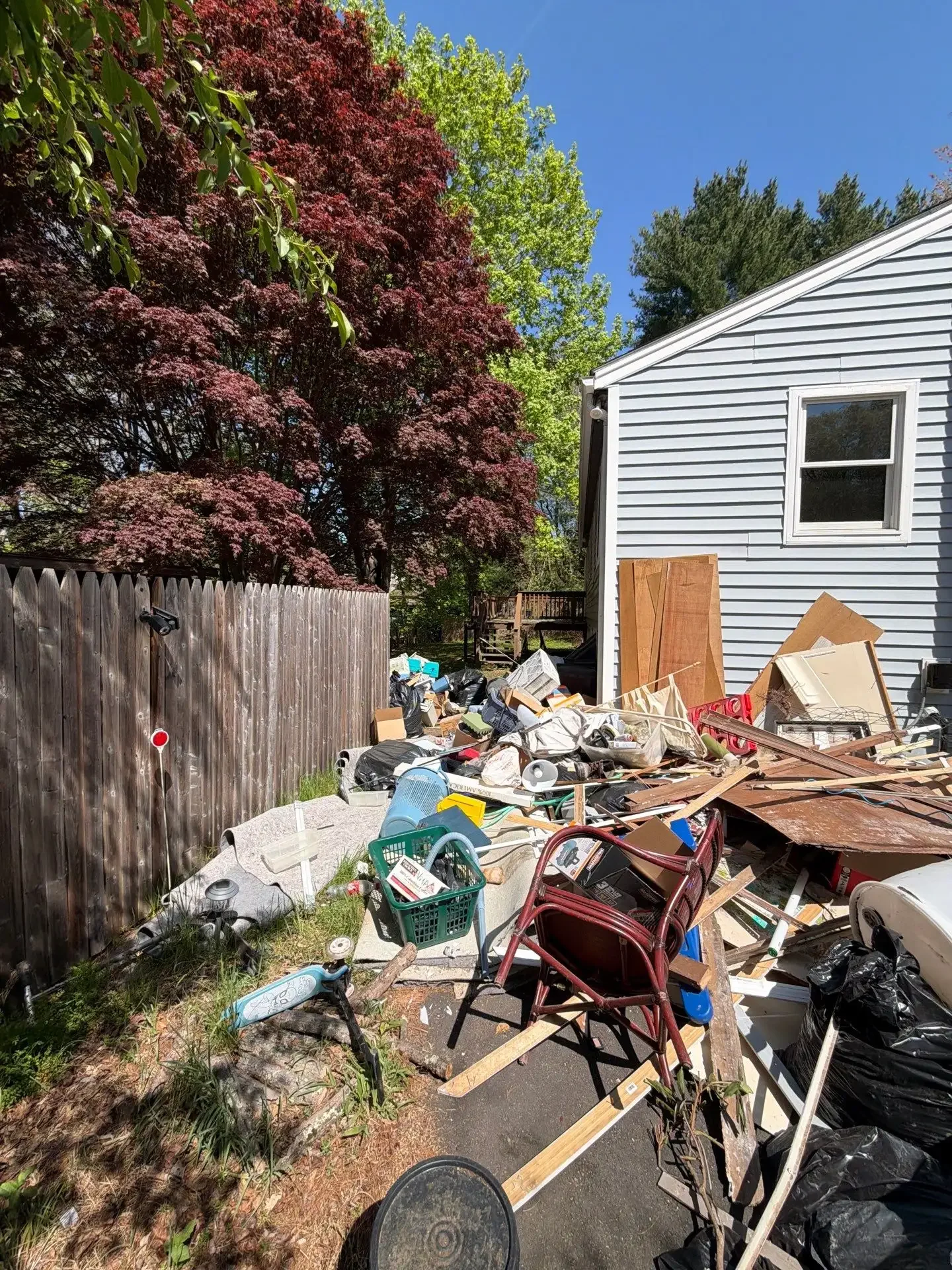 Furniture, plywood, and household debris staged for removal during a property cleanout in New Haven County.