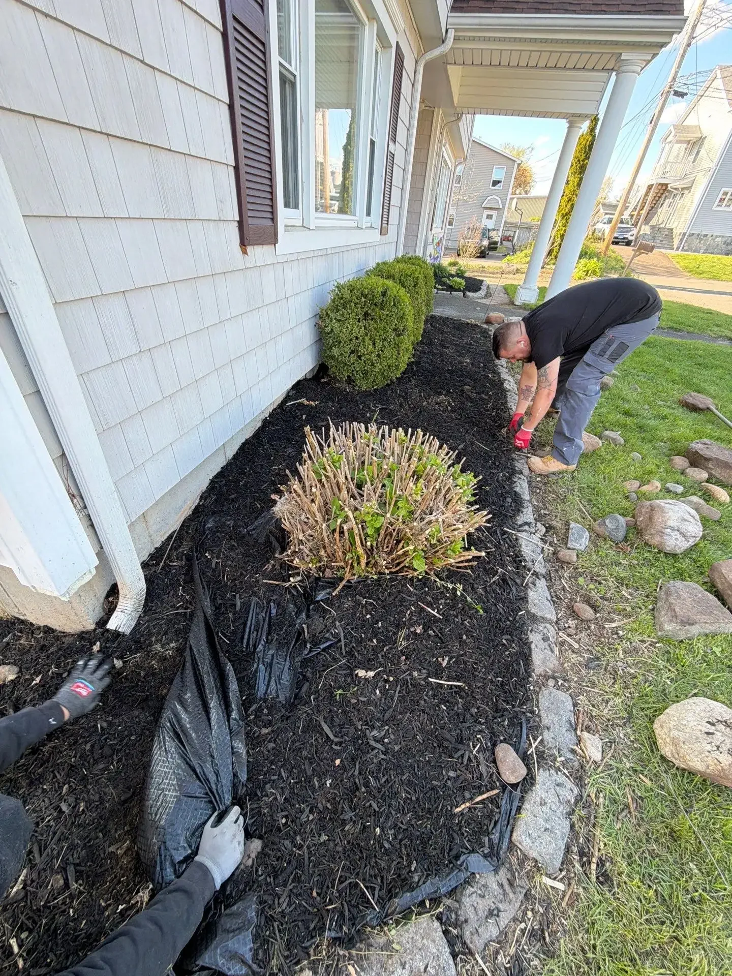 Diamond Image crew member performing landscape bed cleanup and mulch refresh at rental property in Connecticut