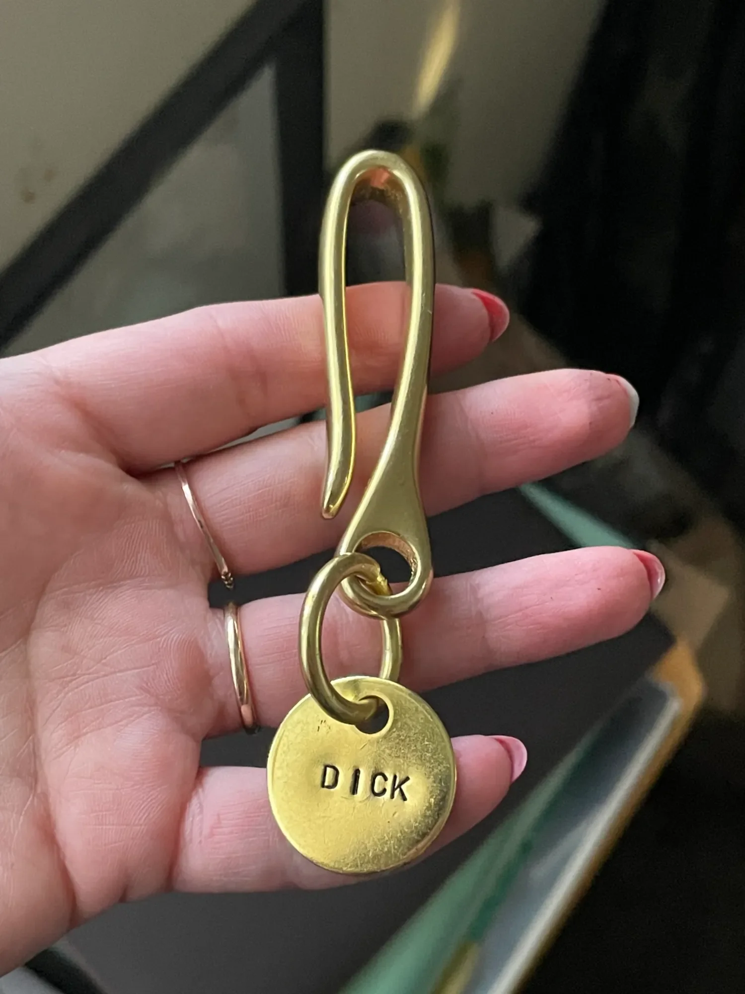 Engraved brass fish hook keychain with car keys attached on white background