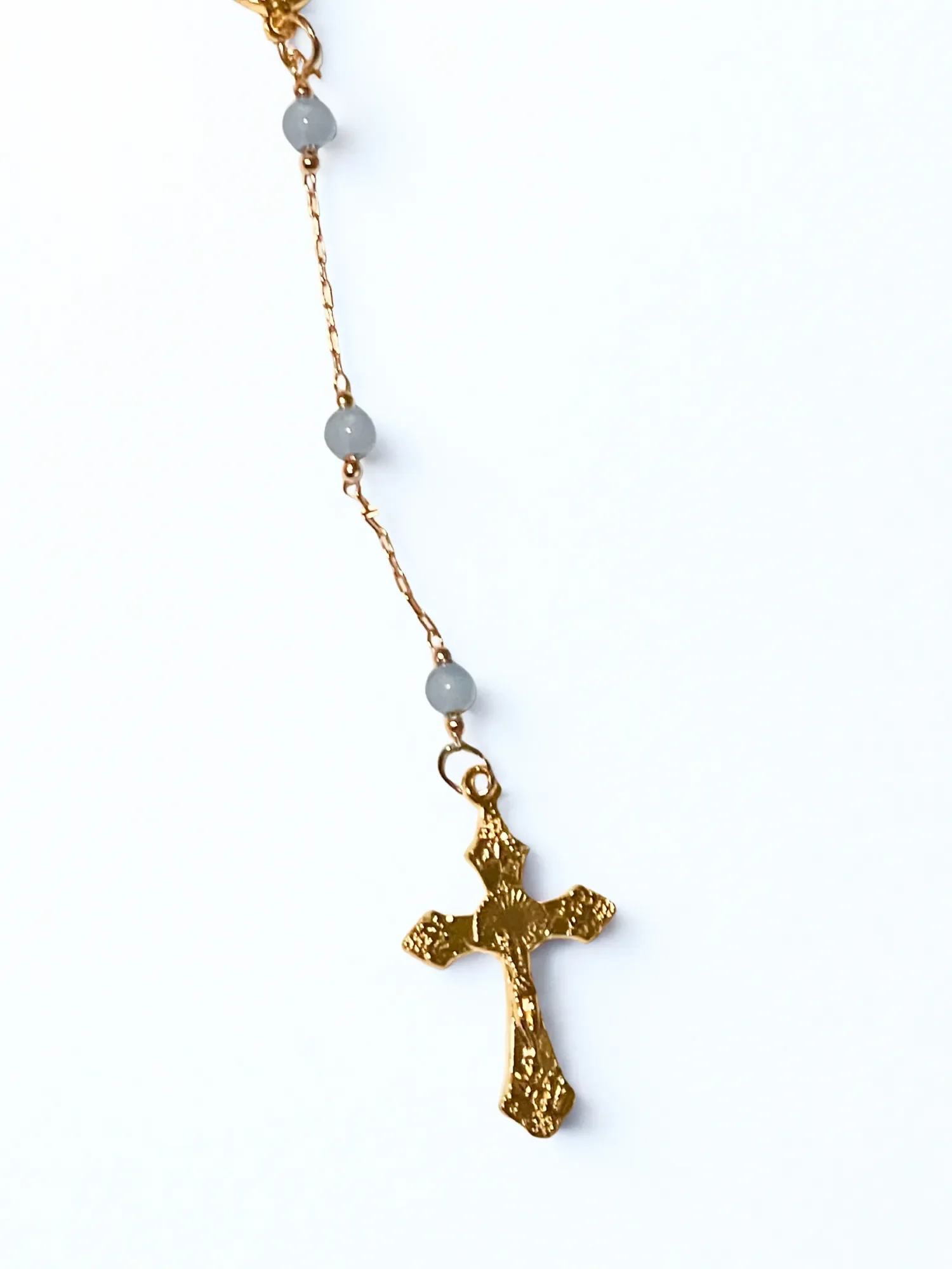 Close up of gold and pale blue beaded one-decade Rosary to hang on rearview mirror of car