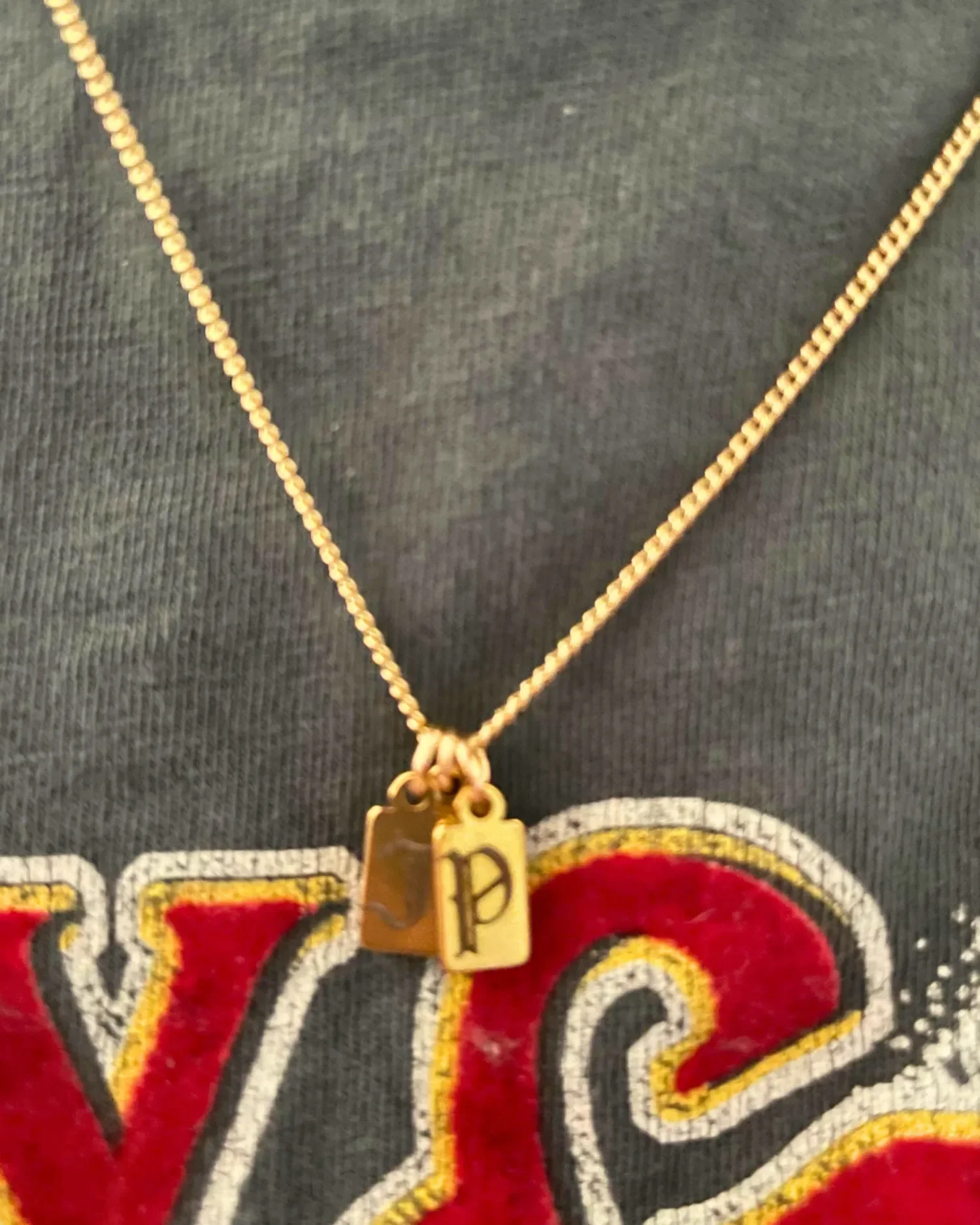 Minimal gold engraved tag necklace worn as everyday jewelry