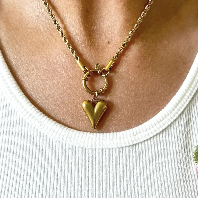 Woman wearing gold heart pendant carabiner clip necklace