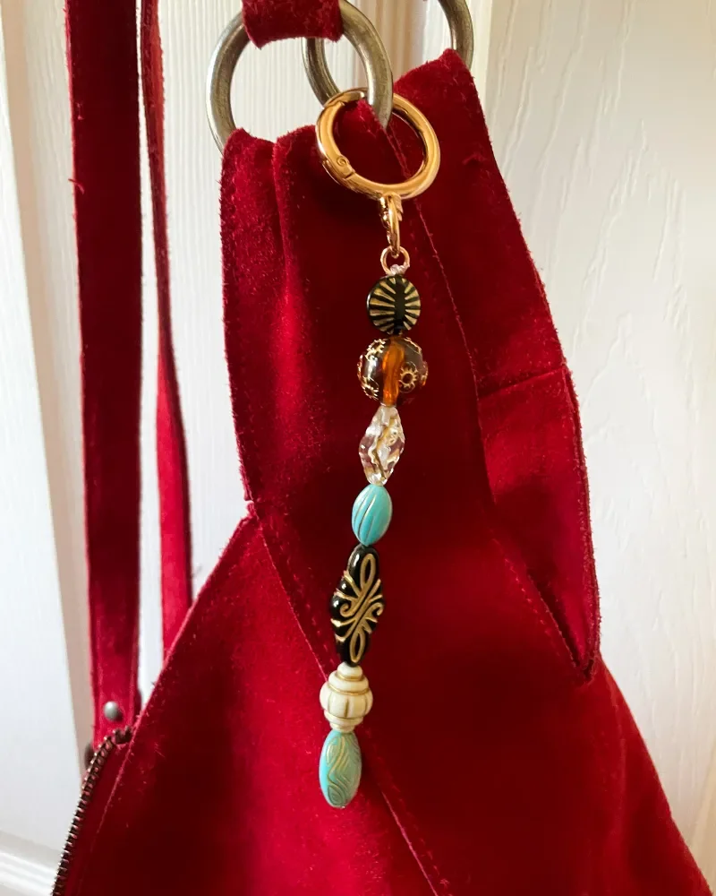 beaded bag charm on red suede purse