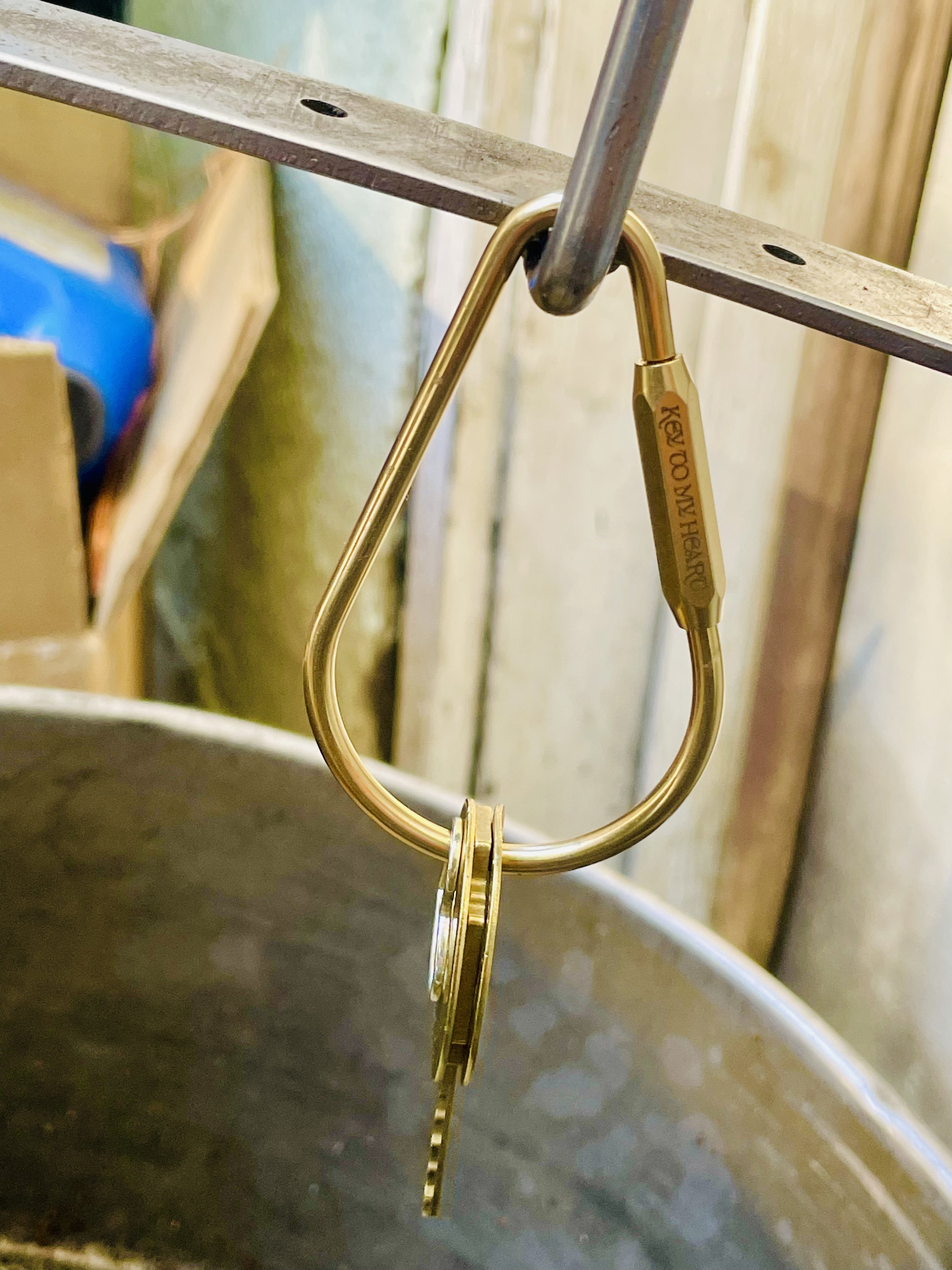 Custom engraved brass teardrop key ring with hex screw lock, attached to a belt loop – sleek everyday carry accessory for men and women.