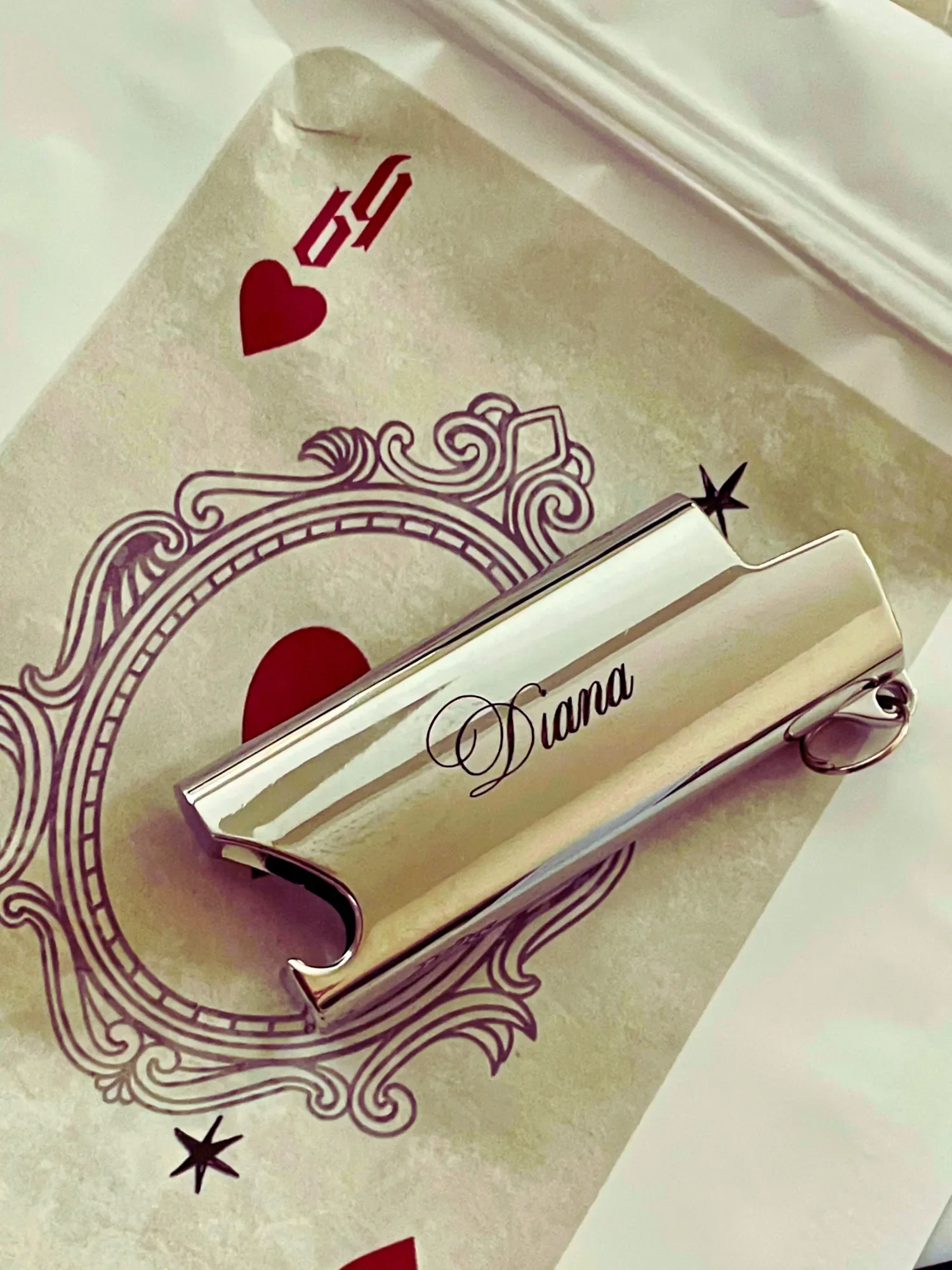 custom engraved mini bic lighter cover keychain laying on Babe's Hardware bag packaging