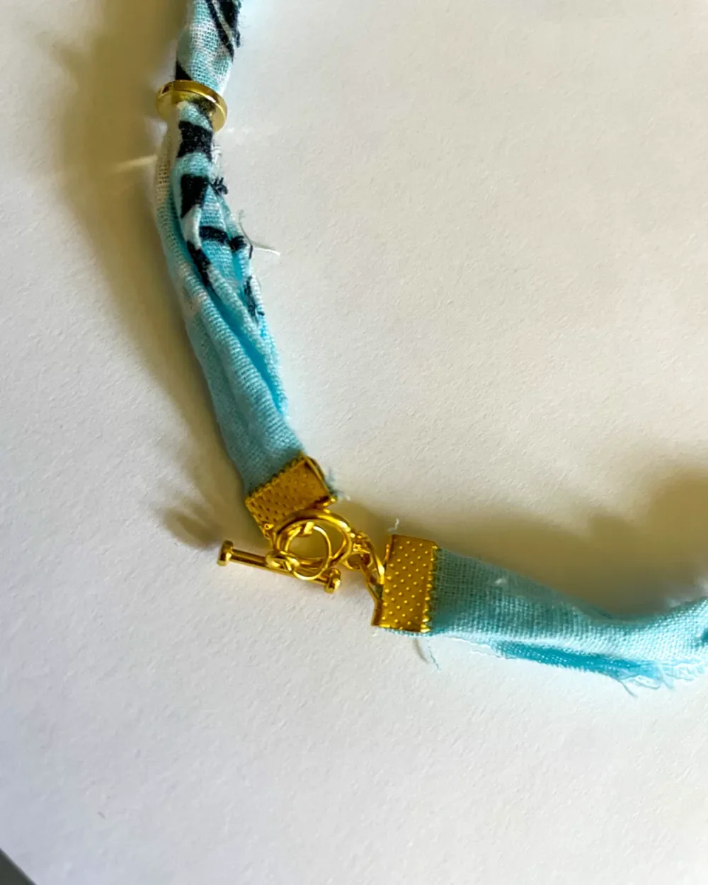 Baby Blue Bandana Charm Necklace with close-up gold hardware
