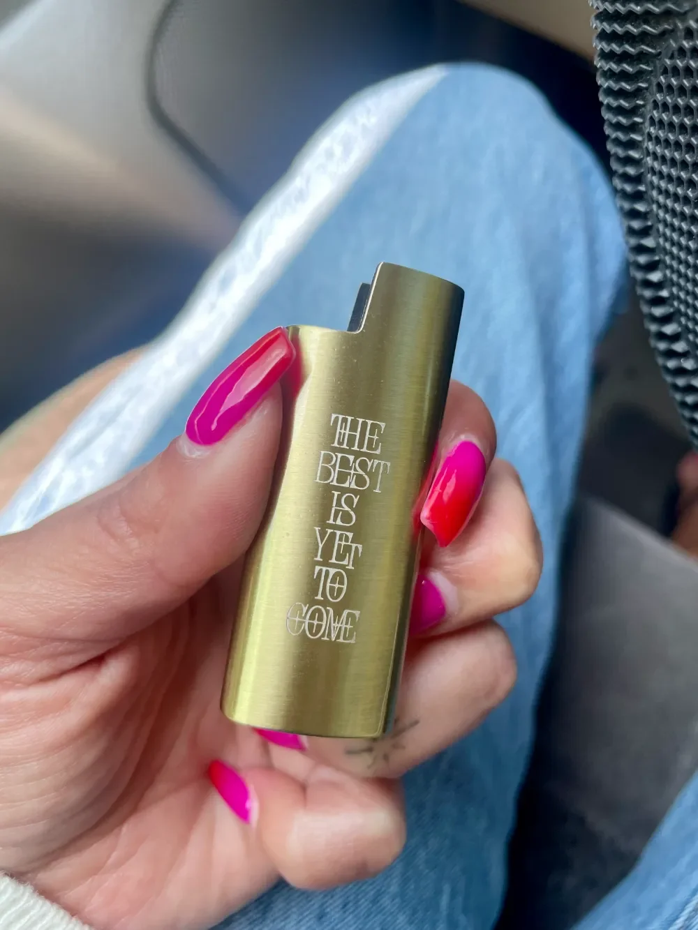 Hand holding engraved bronze mini bic lighter case