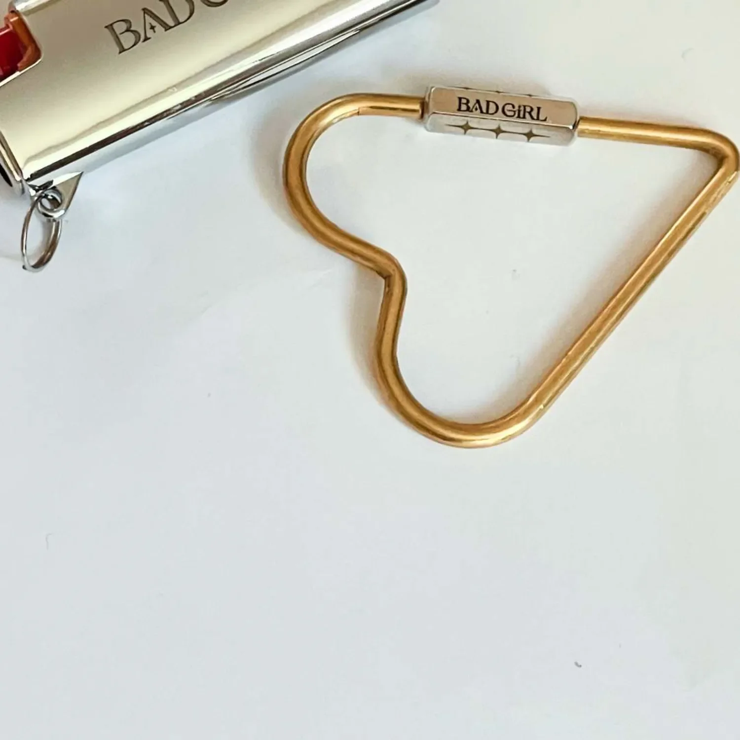 Close-up of brass and silver combo heart carabiner key ring with engraved initials