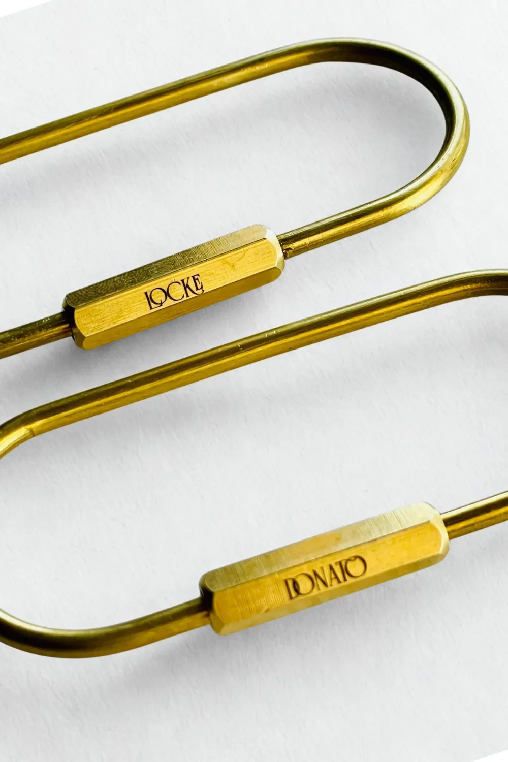 Close up of engraved brass locking carabiner keychains
