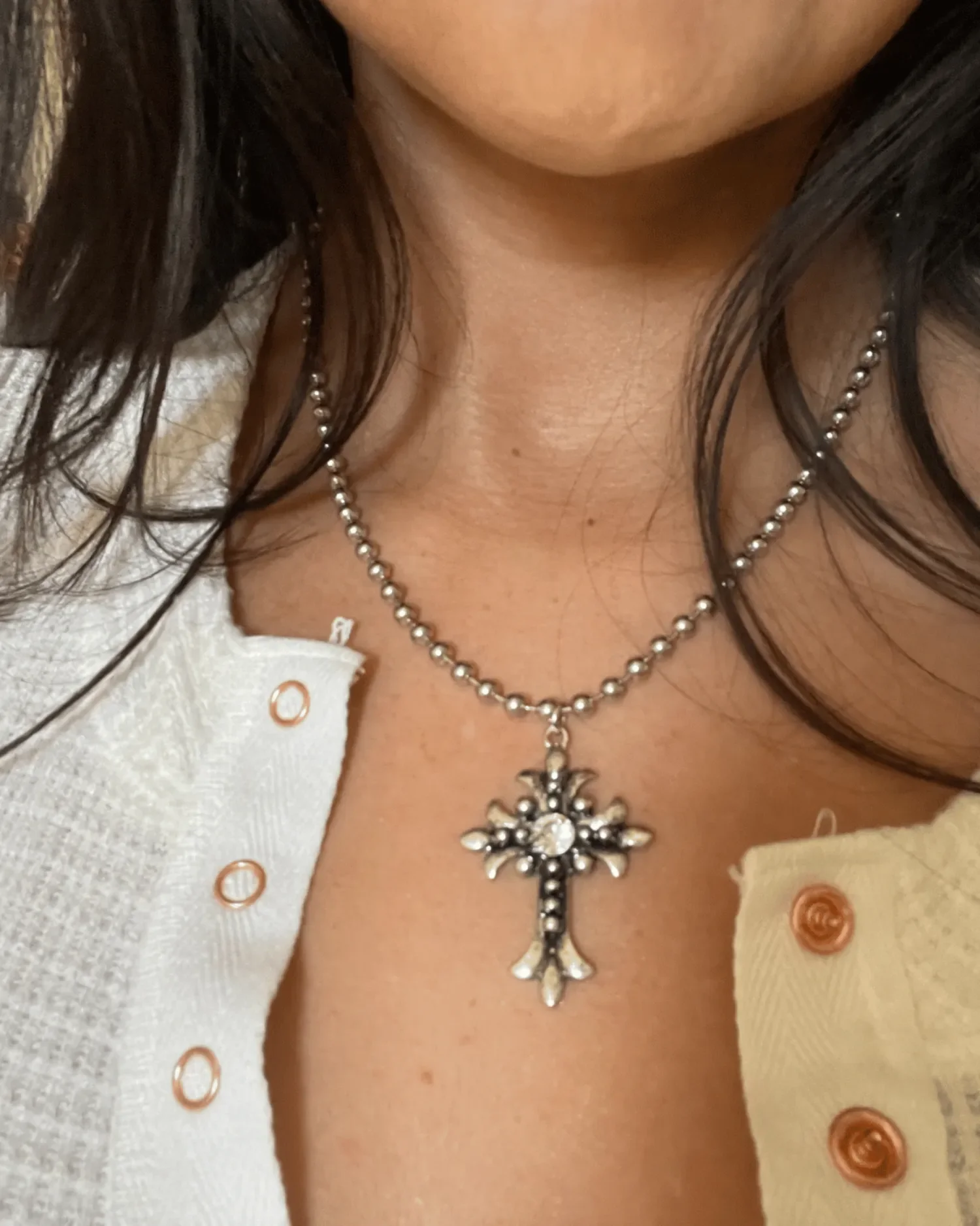 Antique silver Gothic cross pendant with Swarovski crystal center on stainless steel ball chain, styled with white button-up top.