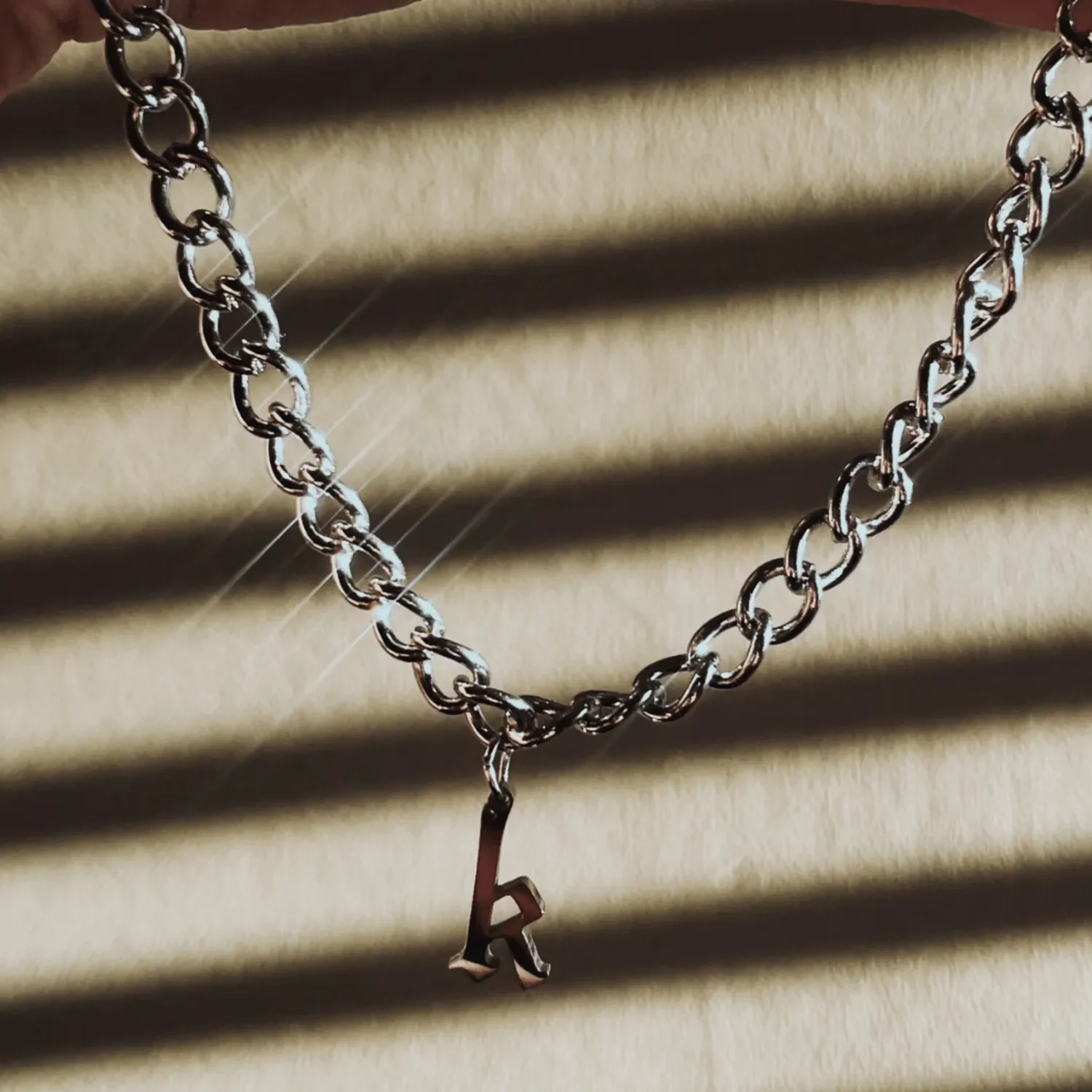 Sterling silver gothic initial necklace styled with layered chains