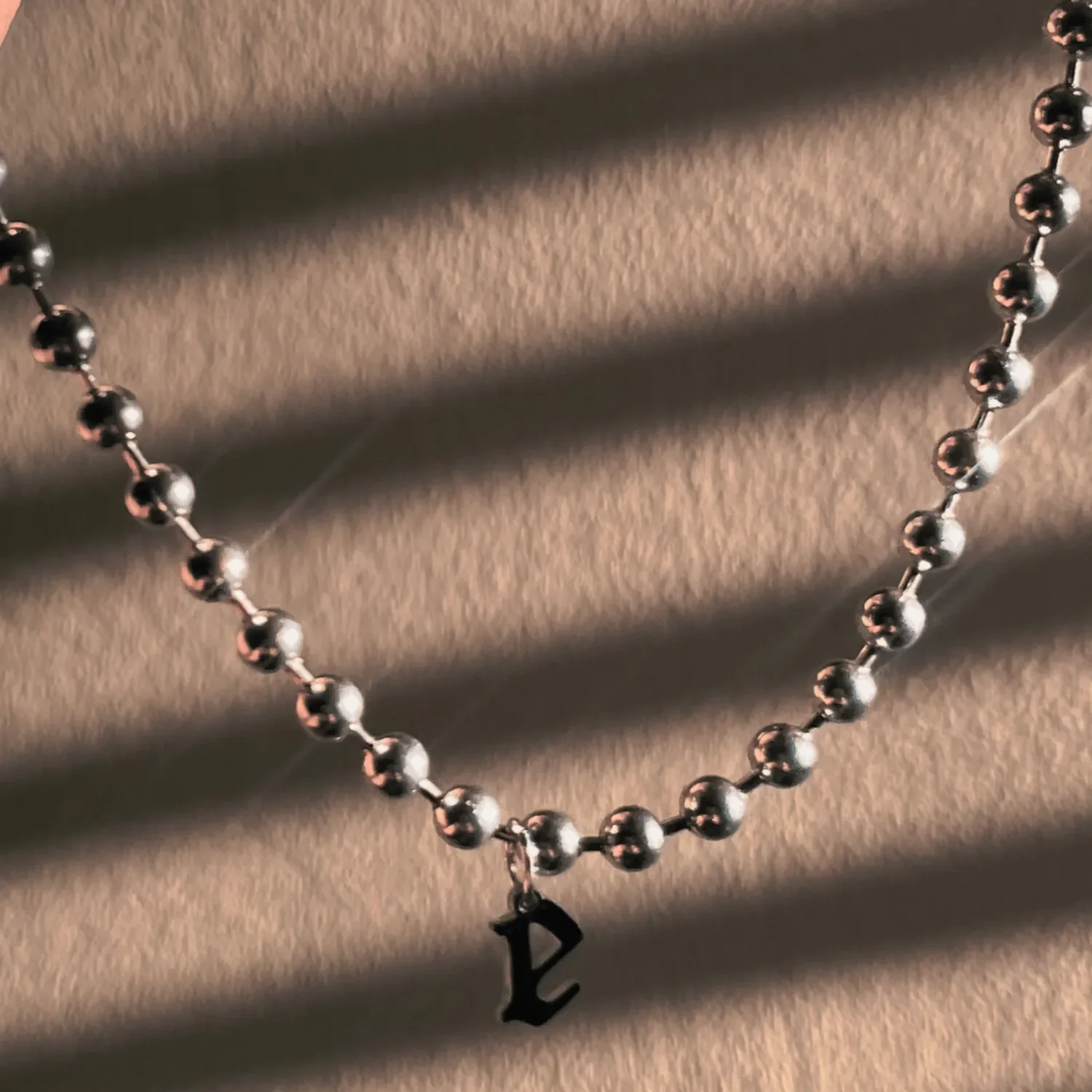 Sterling silver gothic initial necklace styled with layered chains