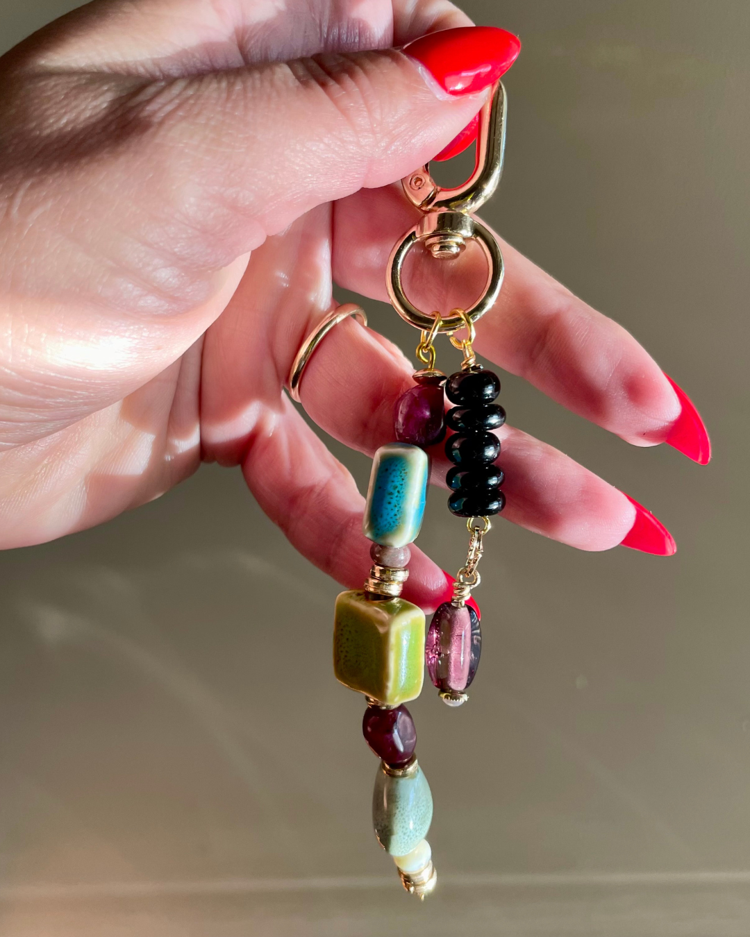 woman holding a double stranded beaded bag charm